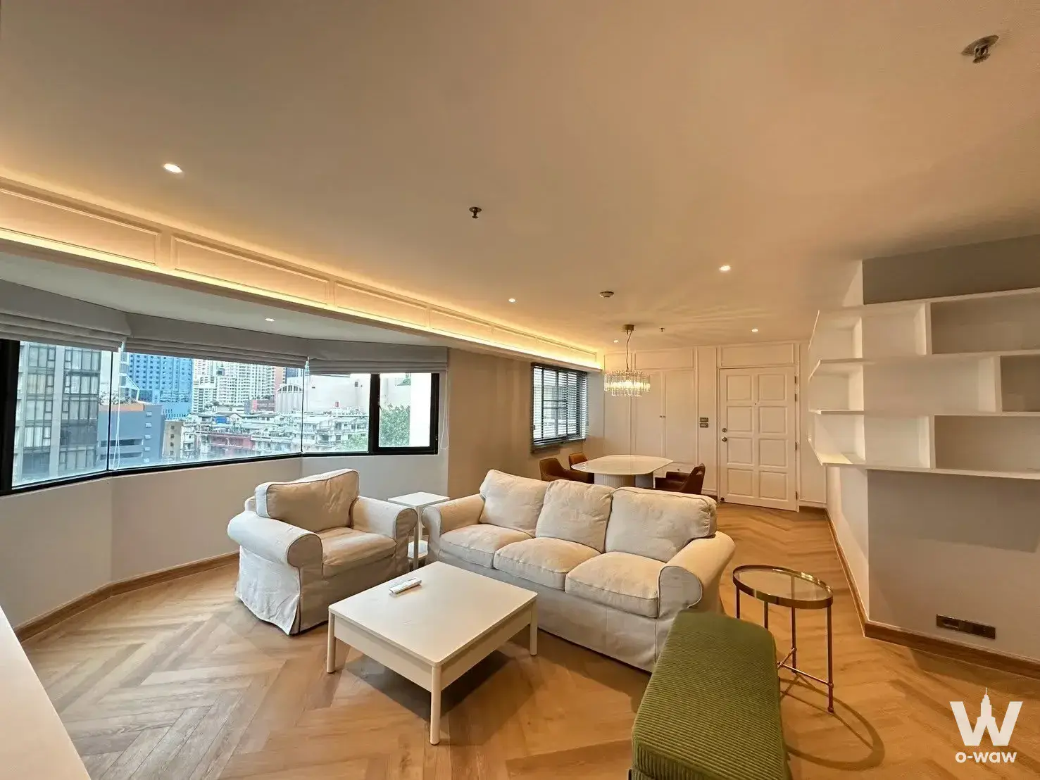Cream sofa and dining set in this 2-bed Baan Suanpetch condo with herringbone floors and city views