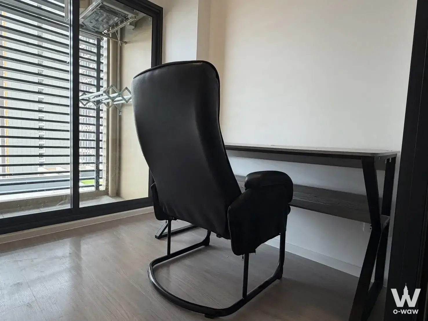 Minimalist home office nook in DENIM Jatujak condo with dark wood desk and sliding glass door to balcony