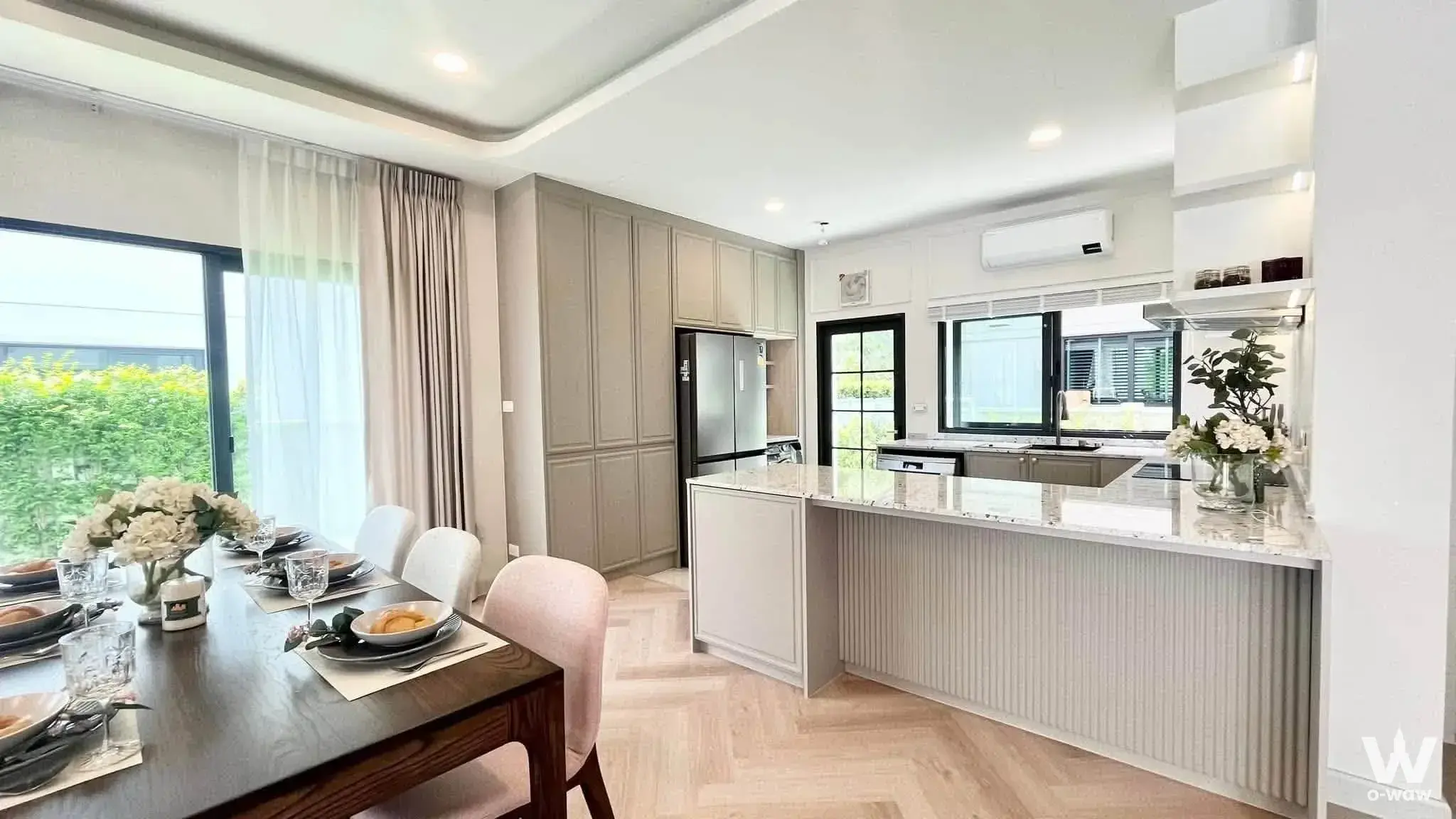Walnut dining table and marble kitchen island in a 4-bed house for sale at Centro Bangna
