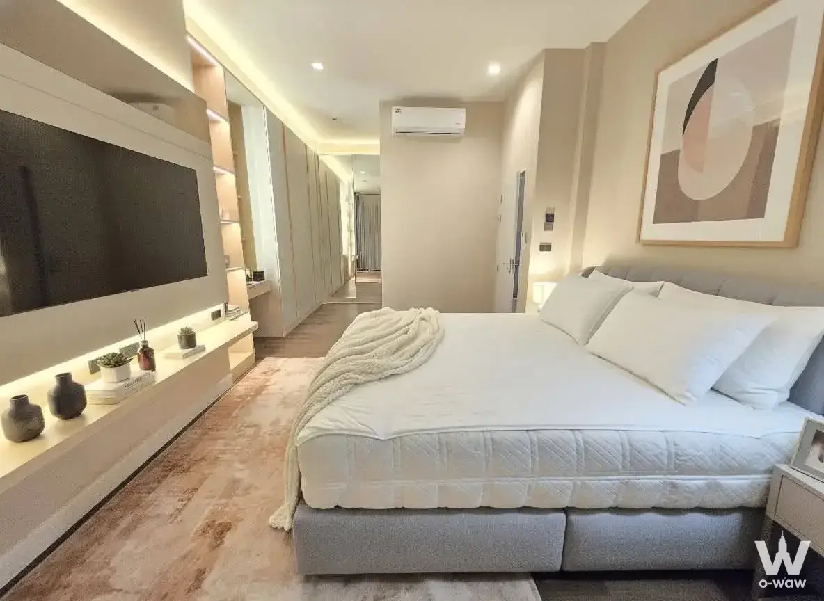 Modern bedroom in Bangkok Boulevard Bangna KM5 rental with queen bed, wall-mounted TV, and built-in wardrobes