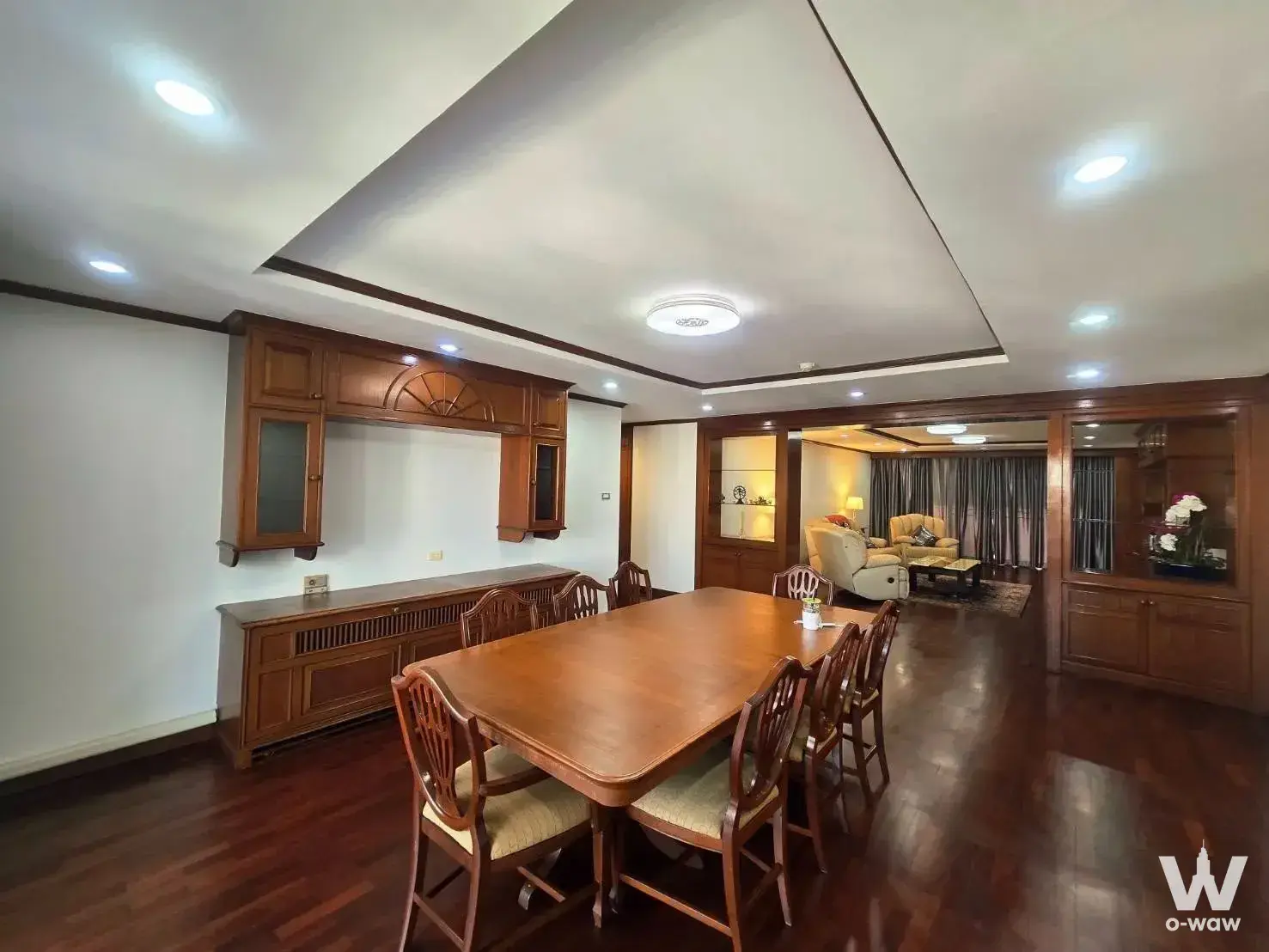 Spacious dining area with polished wooden table and Thai-style woodwork in 3-bed condo for sale at The Regent Bangkok