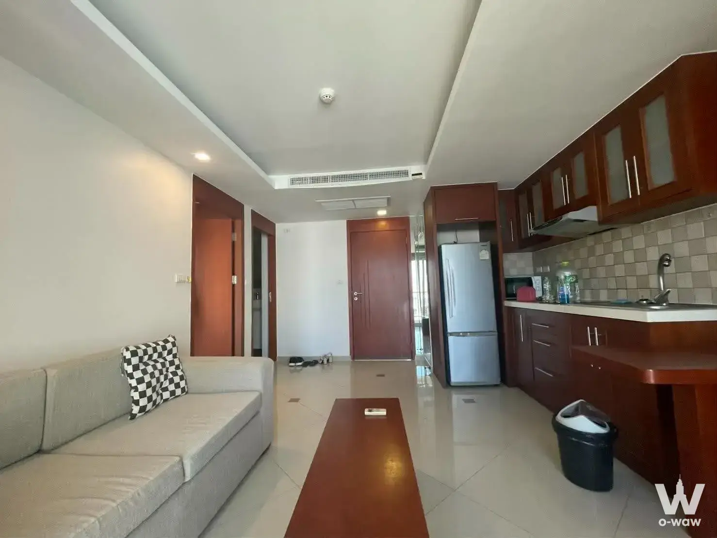 Modern open-plan living and kitchen with dark wood cabinets in a 1-bed condo for rent at City Garden Pattaya