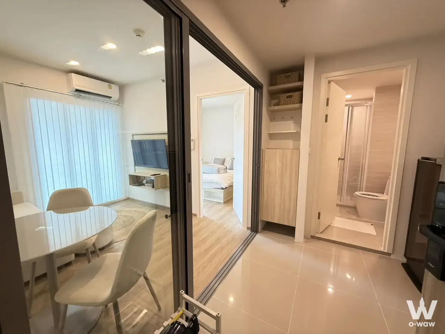Bright 1-bed condo for rent in Phuket with glossy tiled hallway, open-plan living area, and modern minimalist decor