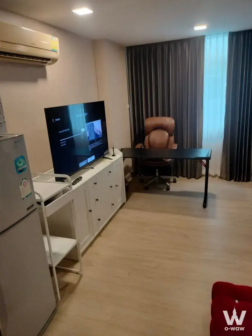 Modern 1-bed condo for rent in J.W. BOULEVARD Srivara with beige floors, TV console, and leather office chair by window