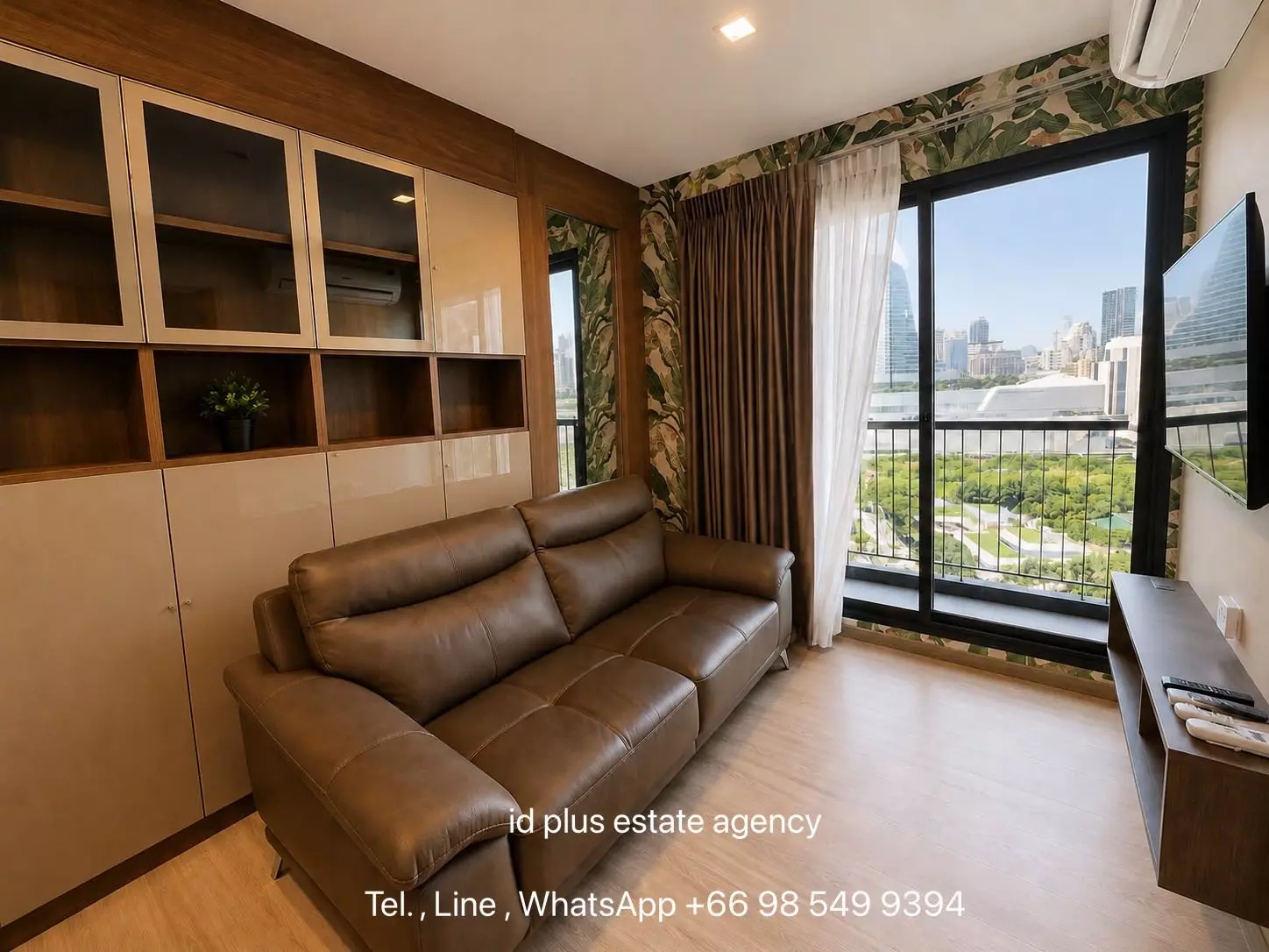 Modern living room with leather sofa and balcony view in 2-bed condo for sale at Life One Wireless