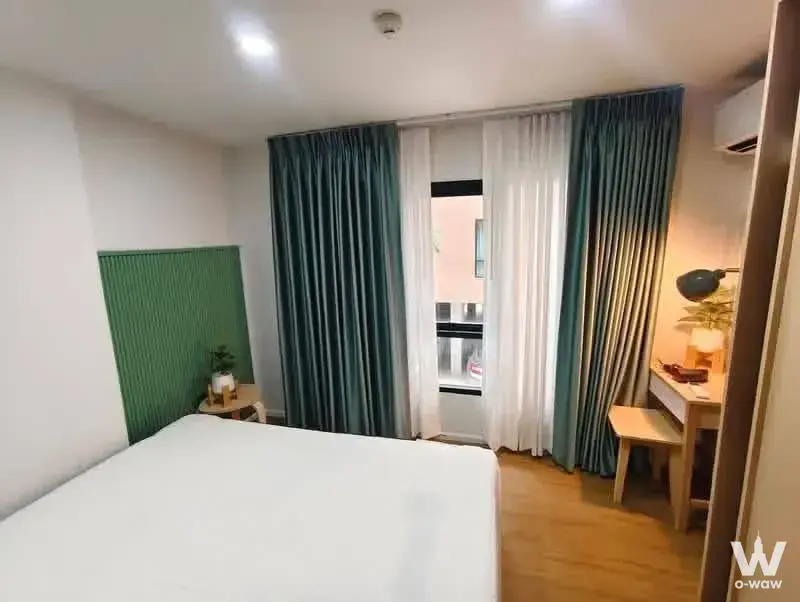 1-bed condo for rent in ALIVE SUKHUMVIT 76 with green slat headboard and teal drapes
