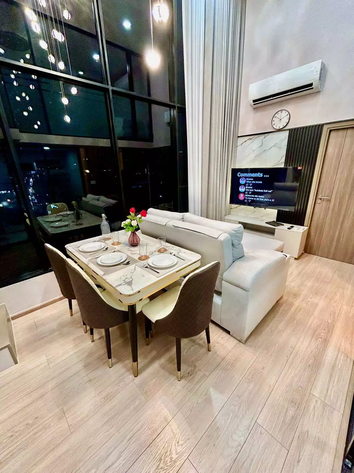 Modern living and dining area in KnightsBridge Space Sukhumvit-Rama 4 condo with city skyline view and marble table