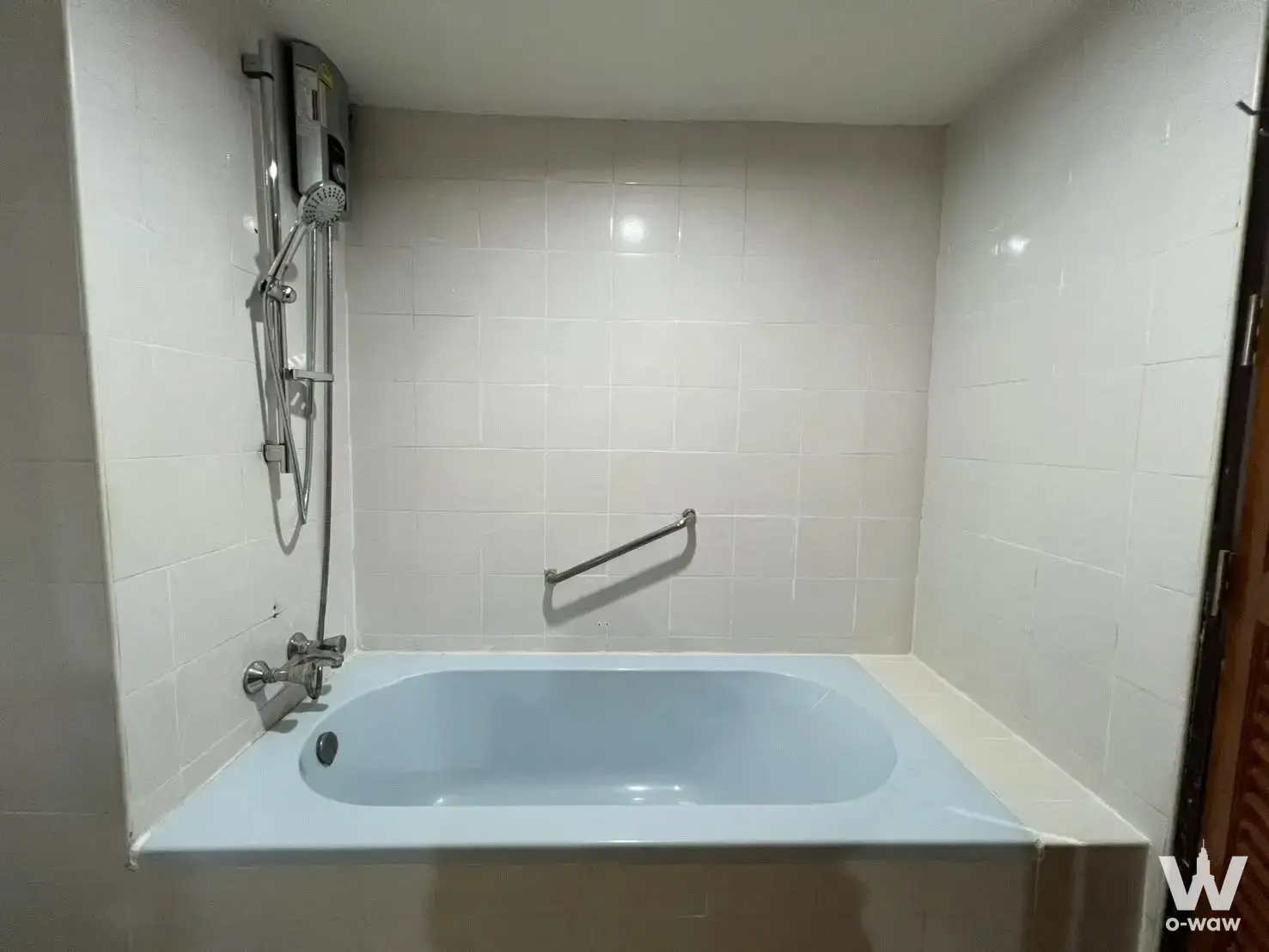 Compact bathroom with built-in tub and grey tiles at Phasuk Place