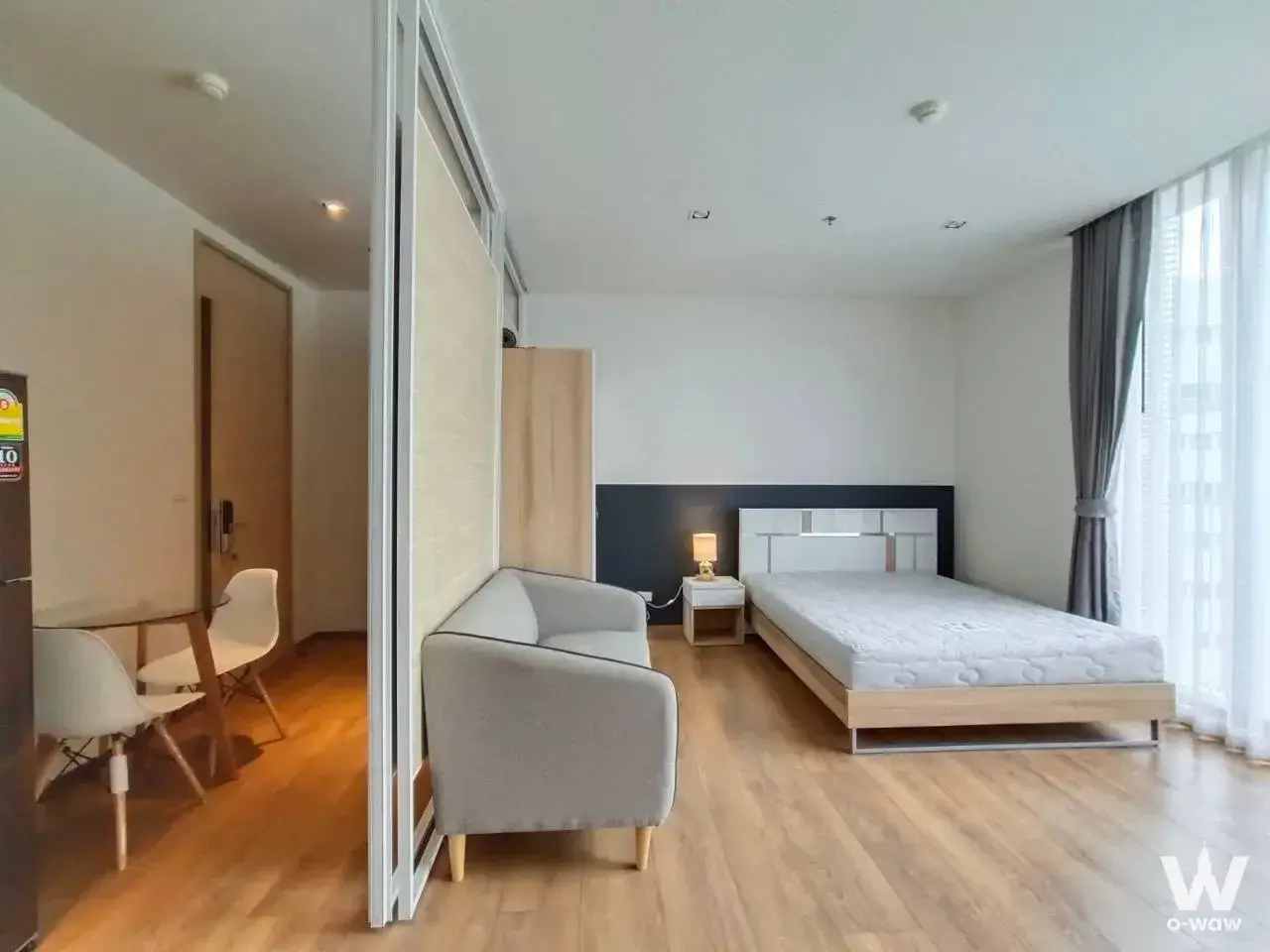Bright 1-bed rental in Park24 with navy accent wall, wooden bed, and floor-to-ceiling windows
