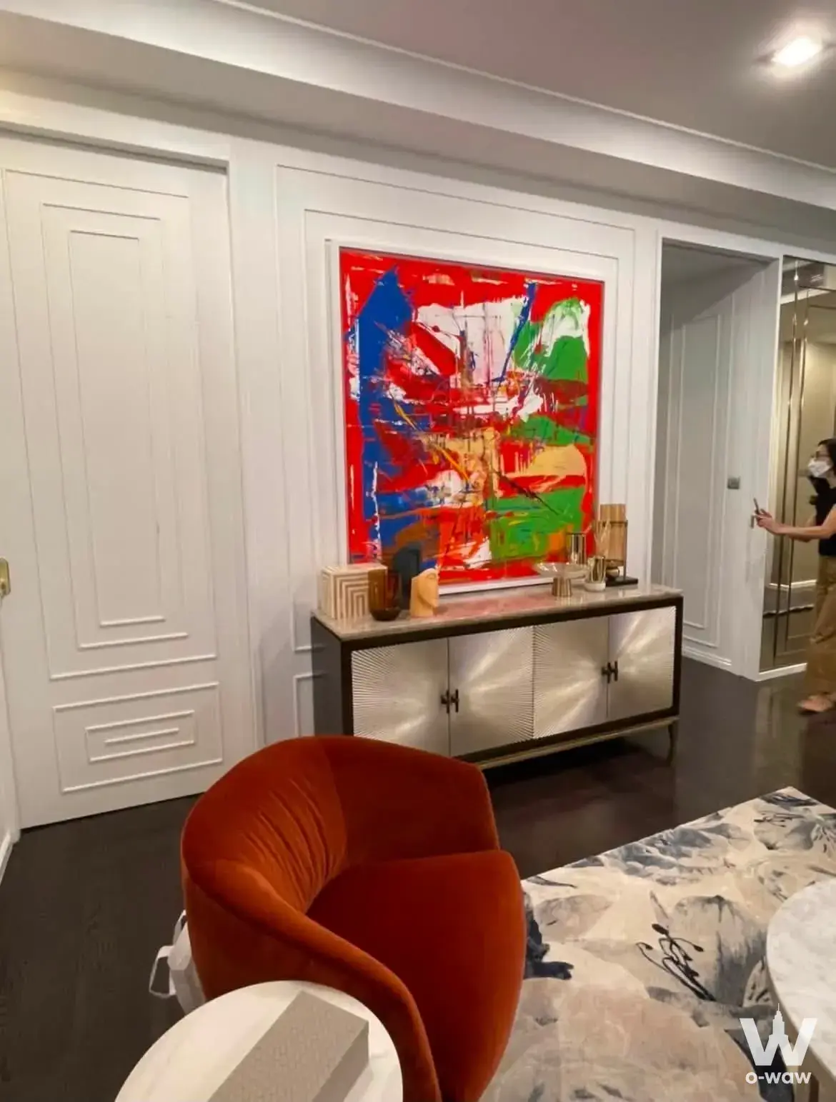 Luxury living room in LAVIQ Sukhumvit 57 featuring dark hardwood floors, abstract art, and velvet chair