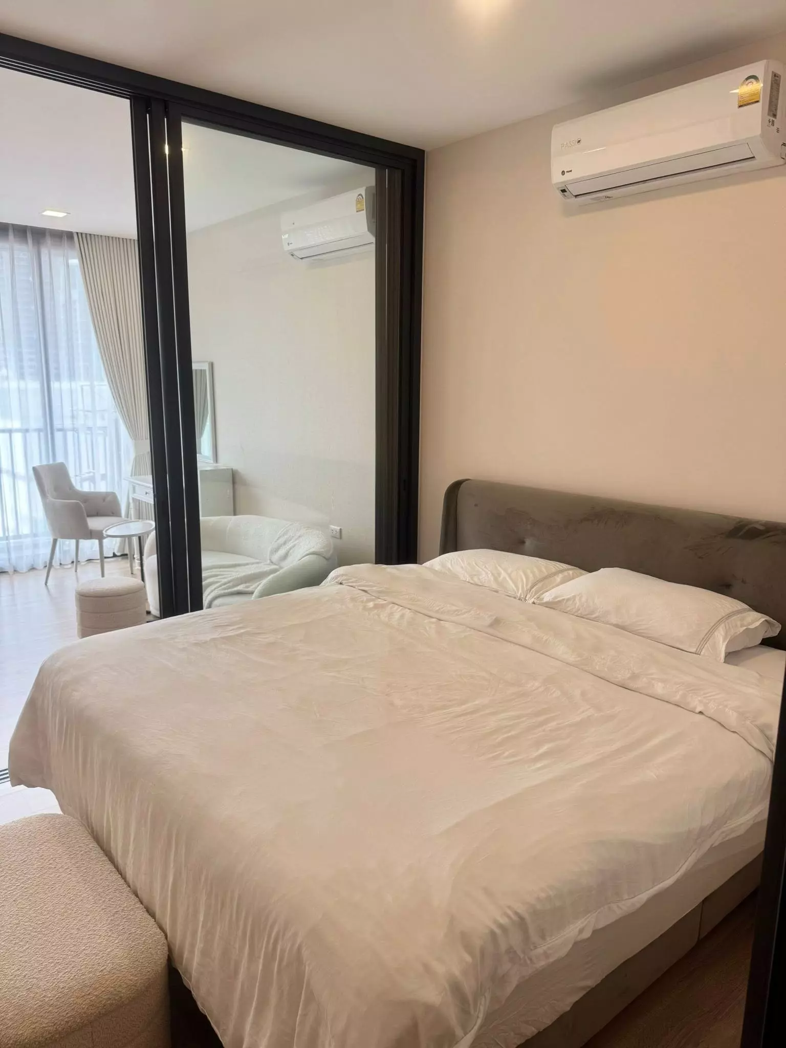 Queen bed with taupe headboard in bright 1-bed condo for rent at XT Phayathai Bangkok