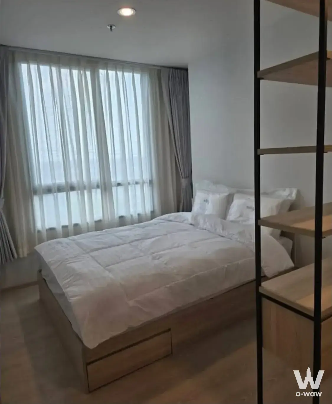 2-bed condo for rent in Nue Mega Plus Bangna bedroom with light wood platform bed and storage