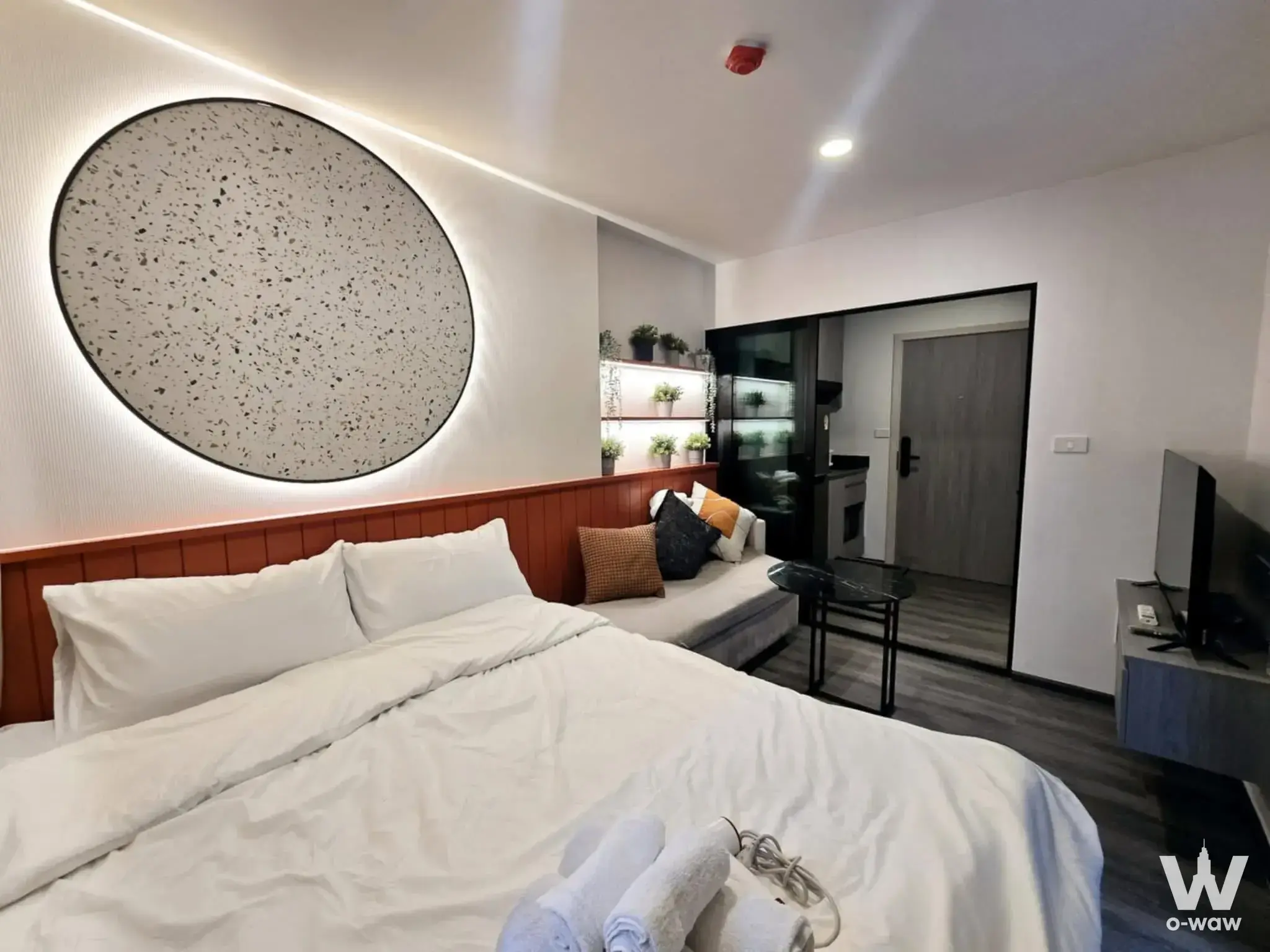 Queen bed in 1-bed condo for rent at The Origin Onnut with terrazzo wall art and wooden headboard