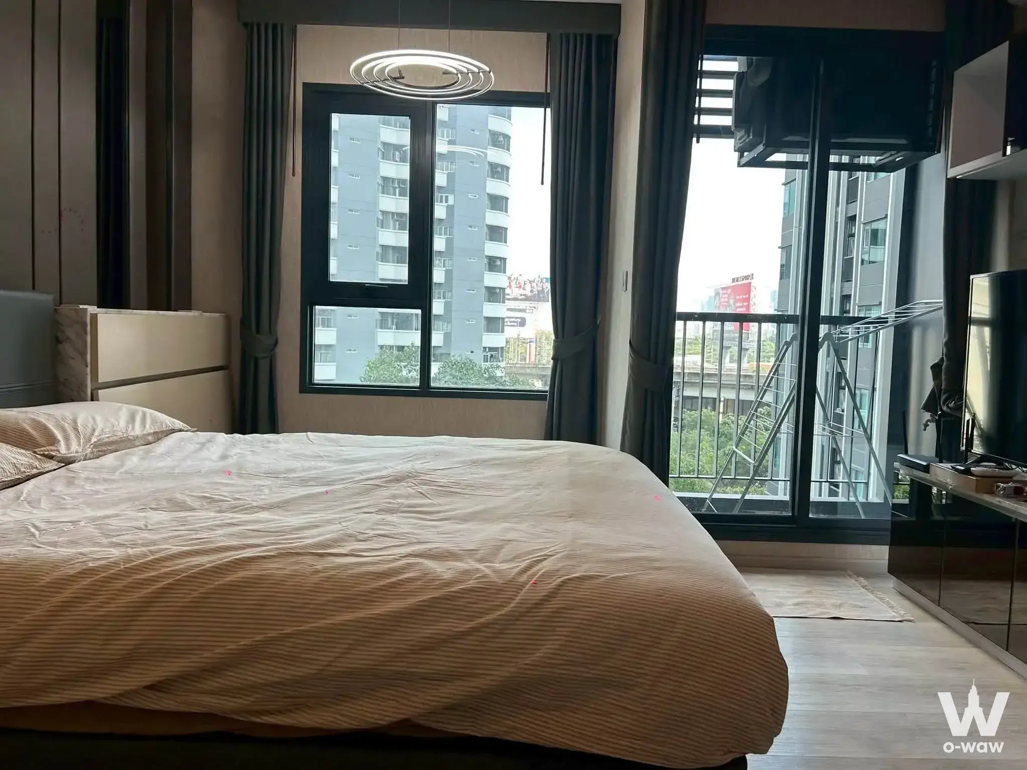 Modern 1-bed condo bedroom in Life One Wireless with wood floors, balcony access, and city views