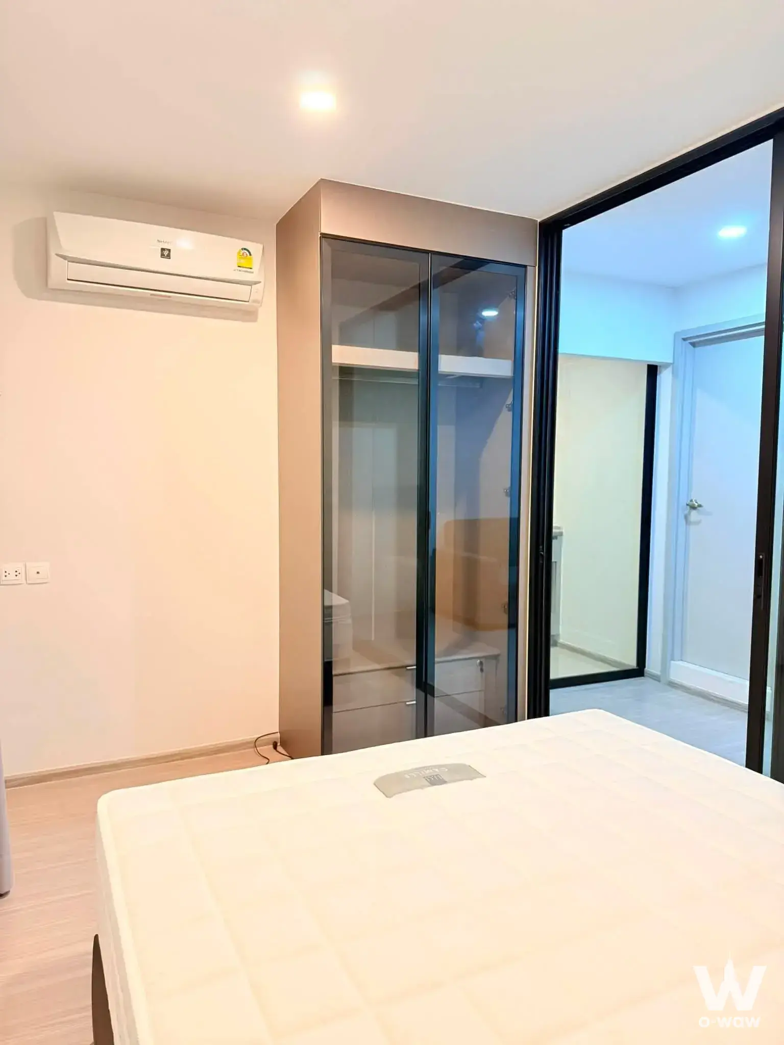 Modern condo bedroom with taupe wardrobe and glass partition