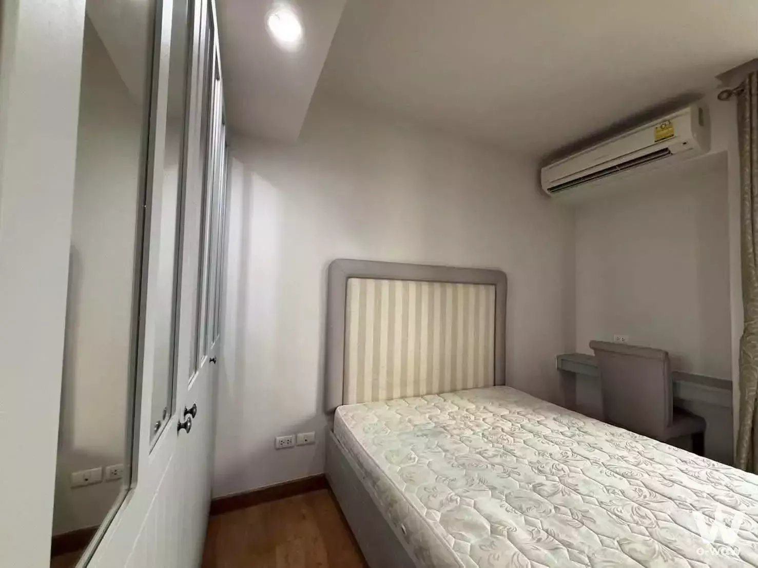 Modern bedroom in 1-bed condo for rent at The Editor Saphan Khwai with striped bed and mirrored wardrobe
