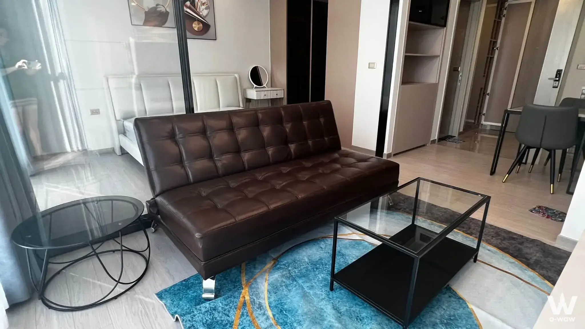 Furnished living room with leather sofa and glass partition bedroom at One9Five Asoke