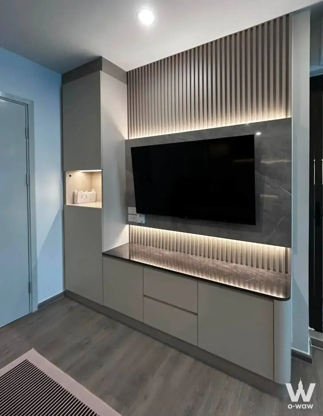 Living room in Regent Home Wutthakat 1-bed condo with grey marble media wall and warm LED lighting