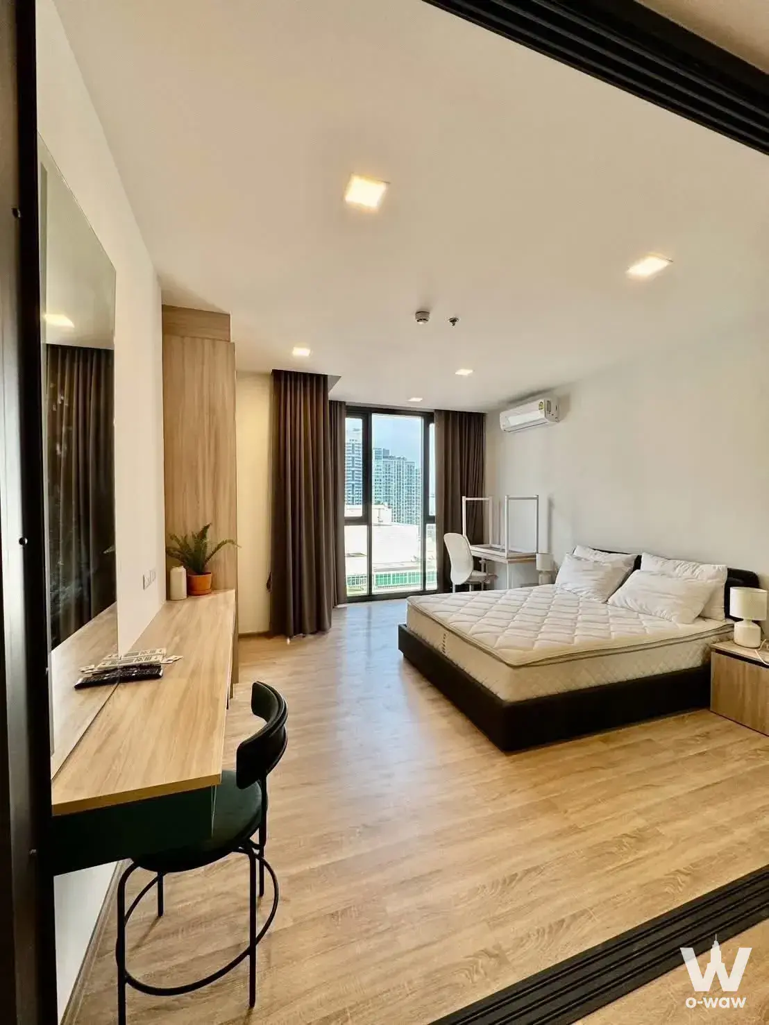 Modern 1-bed condo bedroom at XT Phayathai with oak floors, floating desk, and city views