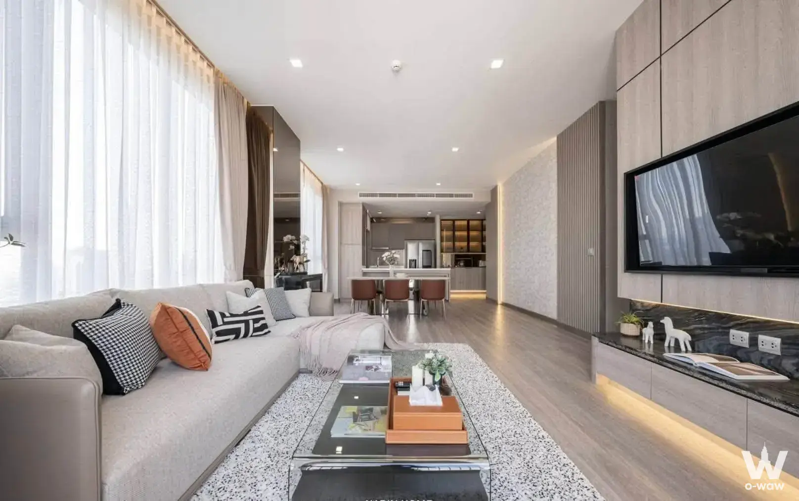 Modern living room in 2-bed condo for sale at Rhythm Charoenkrung Pavillion featuring light wood floors and floor-to-ceiling
