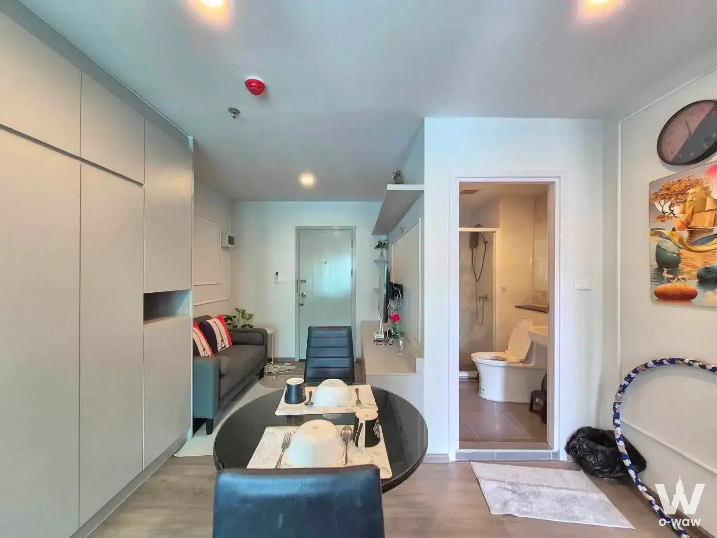 Open-plan studio in Regent Home Bangna with grey sofa and built-in wardrobe