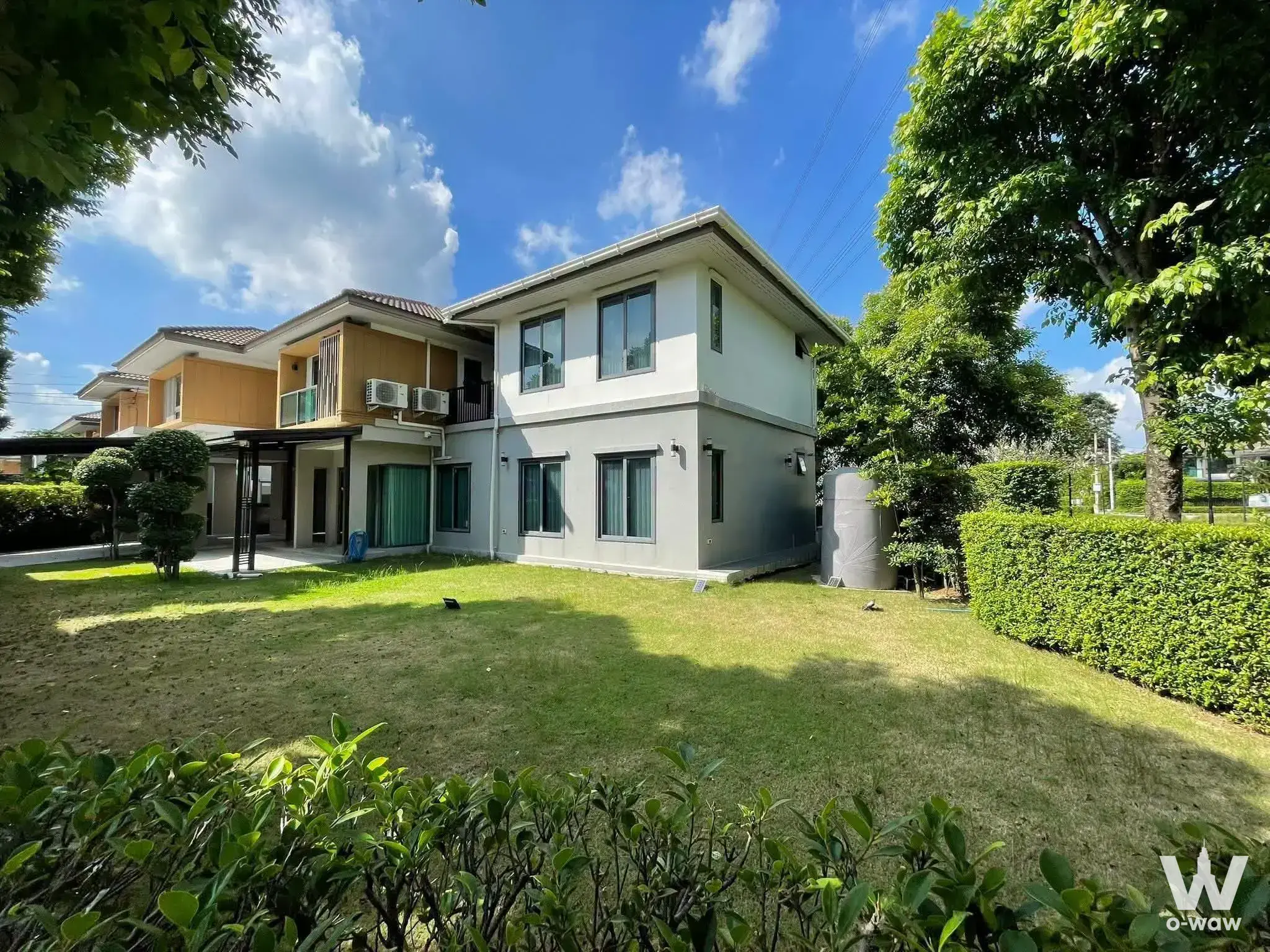 Two-story detached house for sale in Viranya Wongwaen Onnut has white walls, grey trim, balcony, topiary and lawn