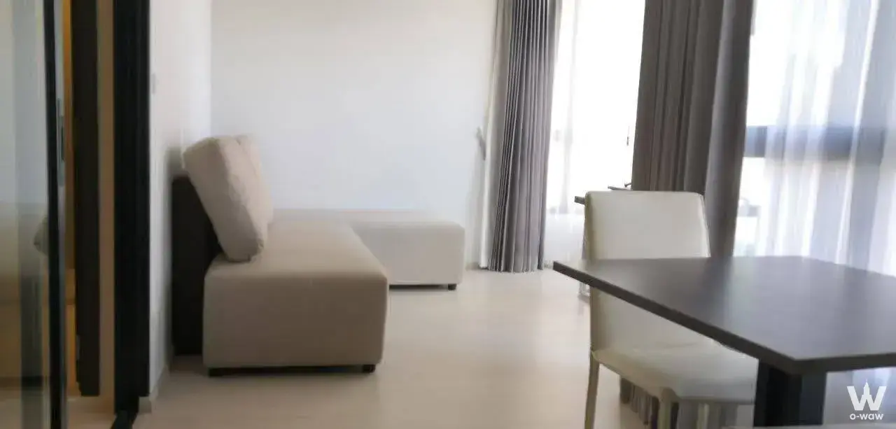 Modern living and dining area in 2-bed ELIO DEL NEST condo with floor-to-ceiling windows and city views