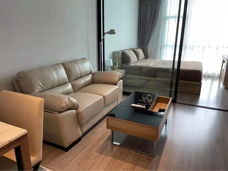 Modern 1-bed condo for rent in Rhythm Ekkamai with glass partition, beige sofa and wood floors