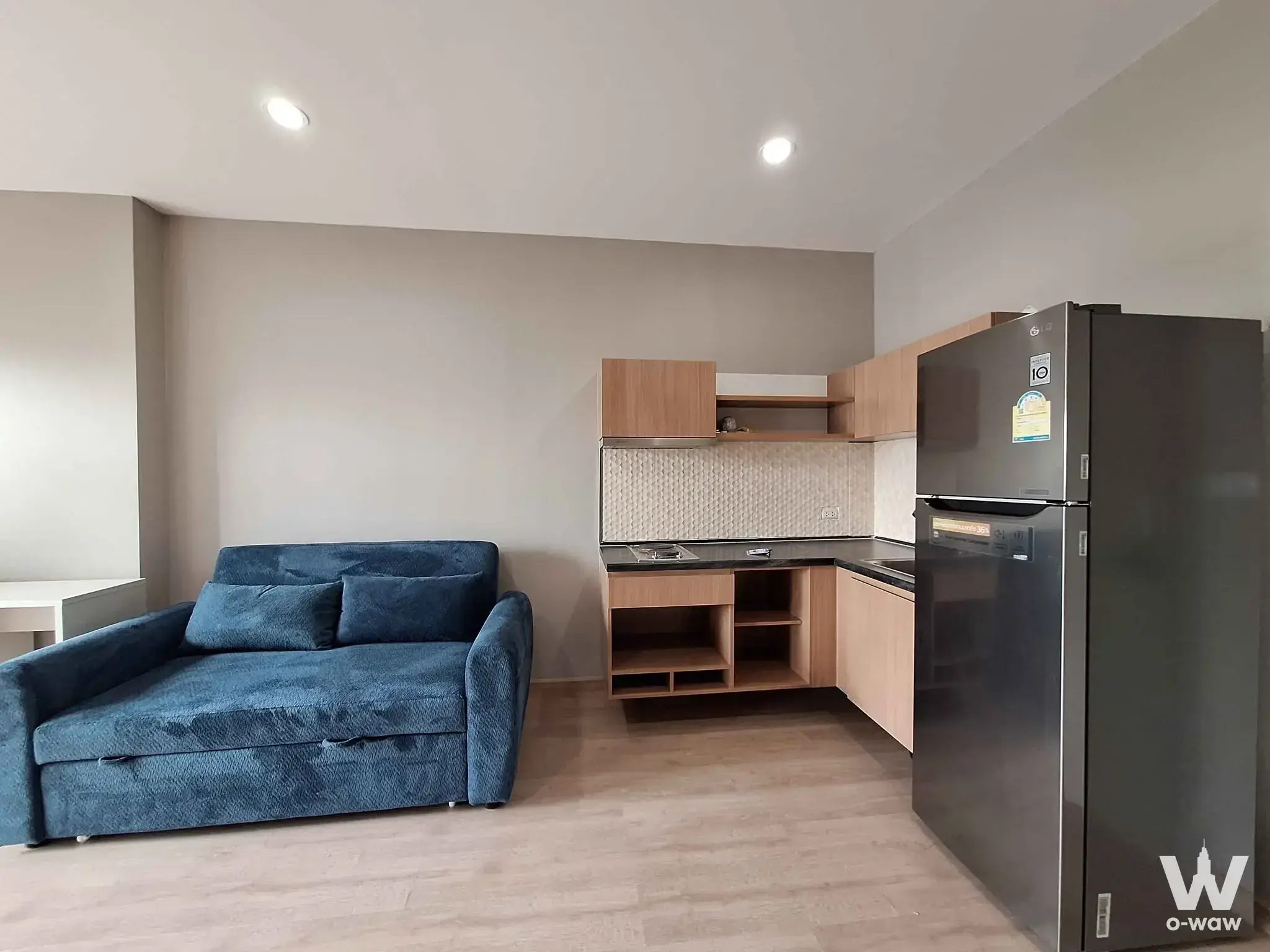 Modern 1-bed condo living area in The Tempo Grand Sathon-Wutthakat with blue sofa and kitchenette