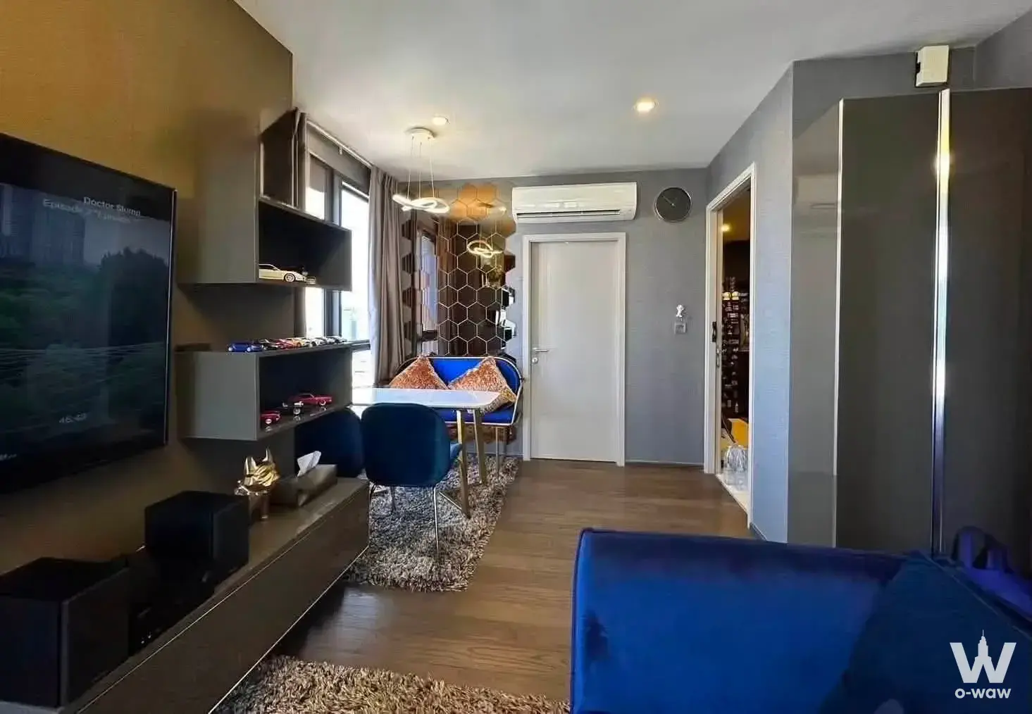 Ideo Q Siam-Ratchathewi dining area with blue velvet sofa and gold table legs