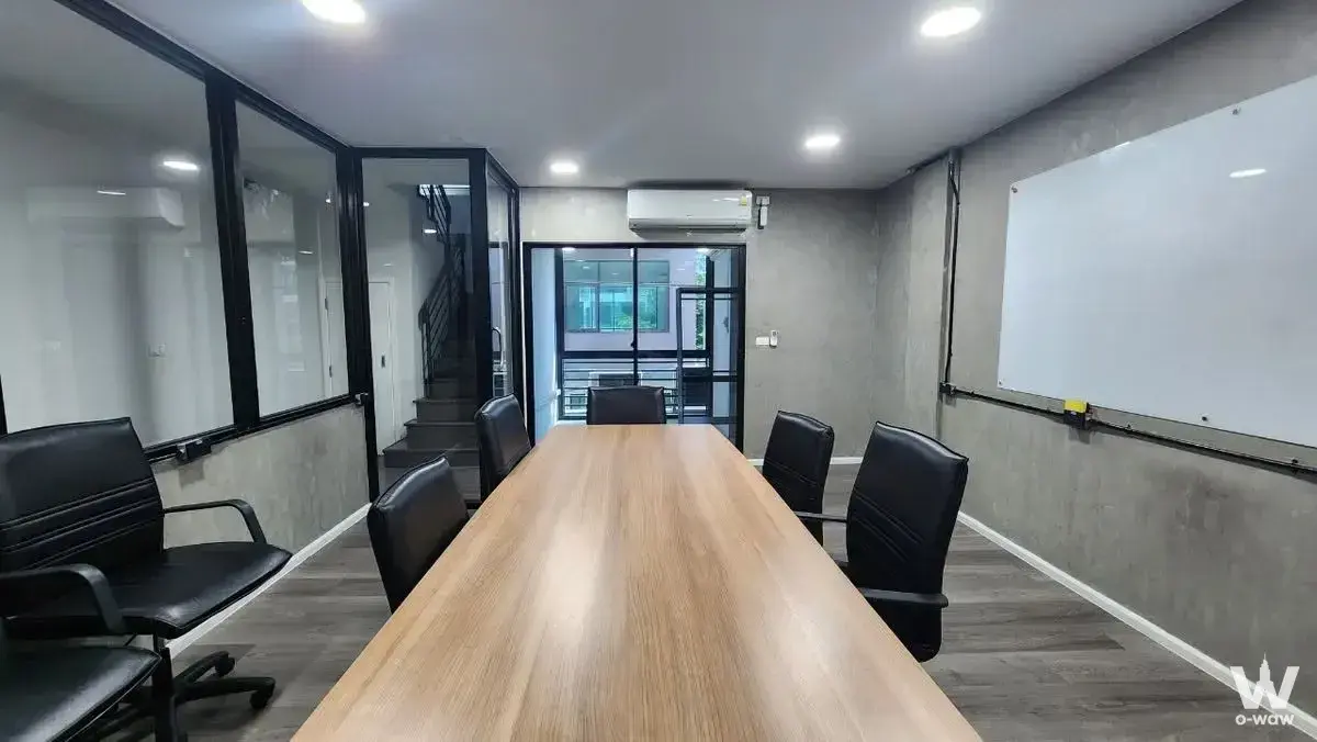 Meeting room in Cascade Bangna condo with long oak table and six leather chairs