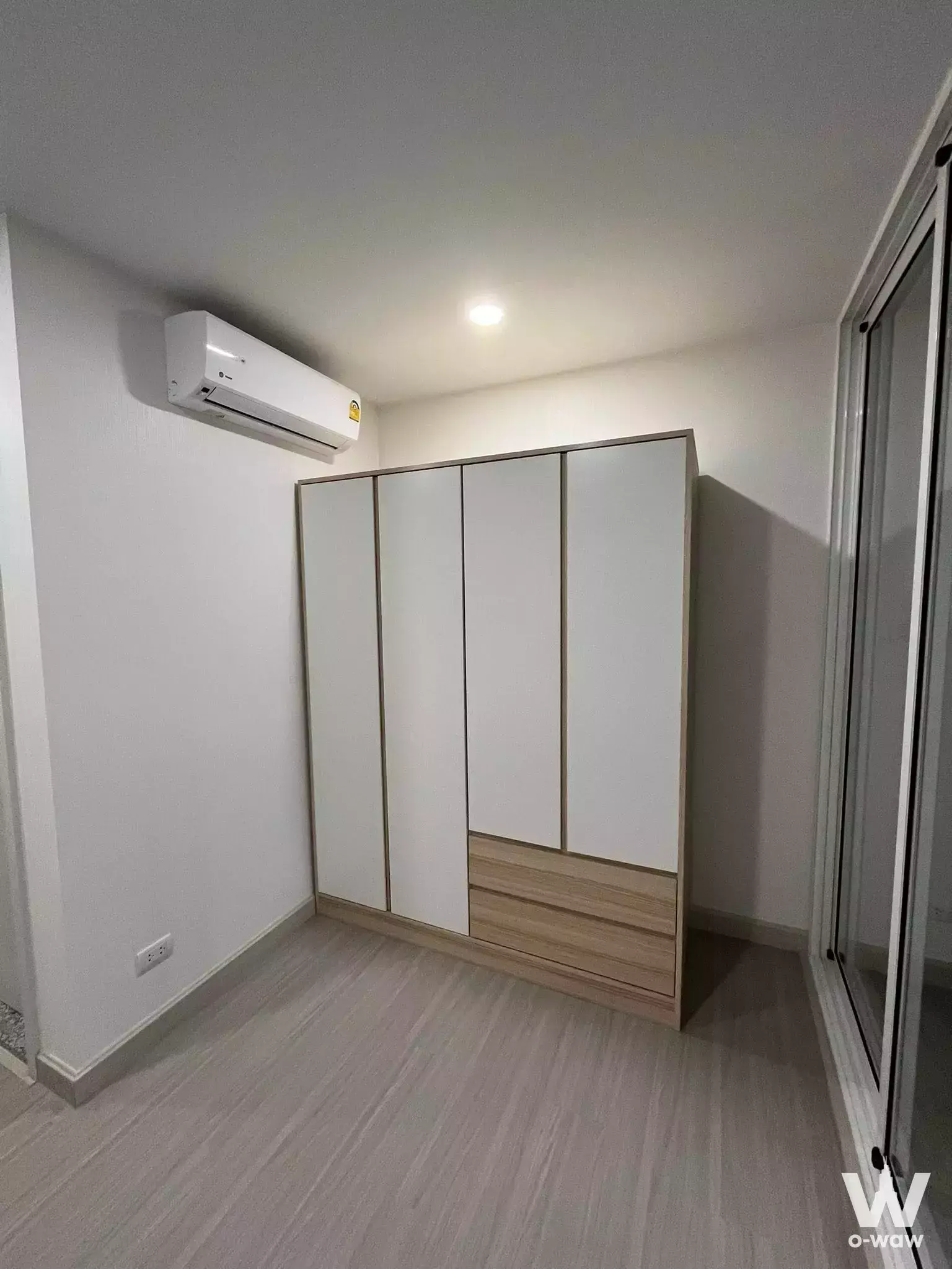 Unfurnished bedroom in Supalai Veranda condo for sale featuring floor-to-ceiling white wardrobe and light grey laminate