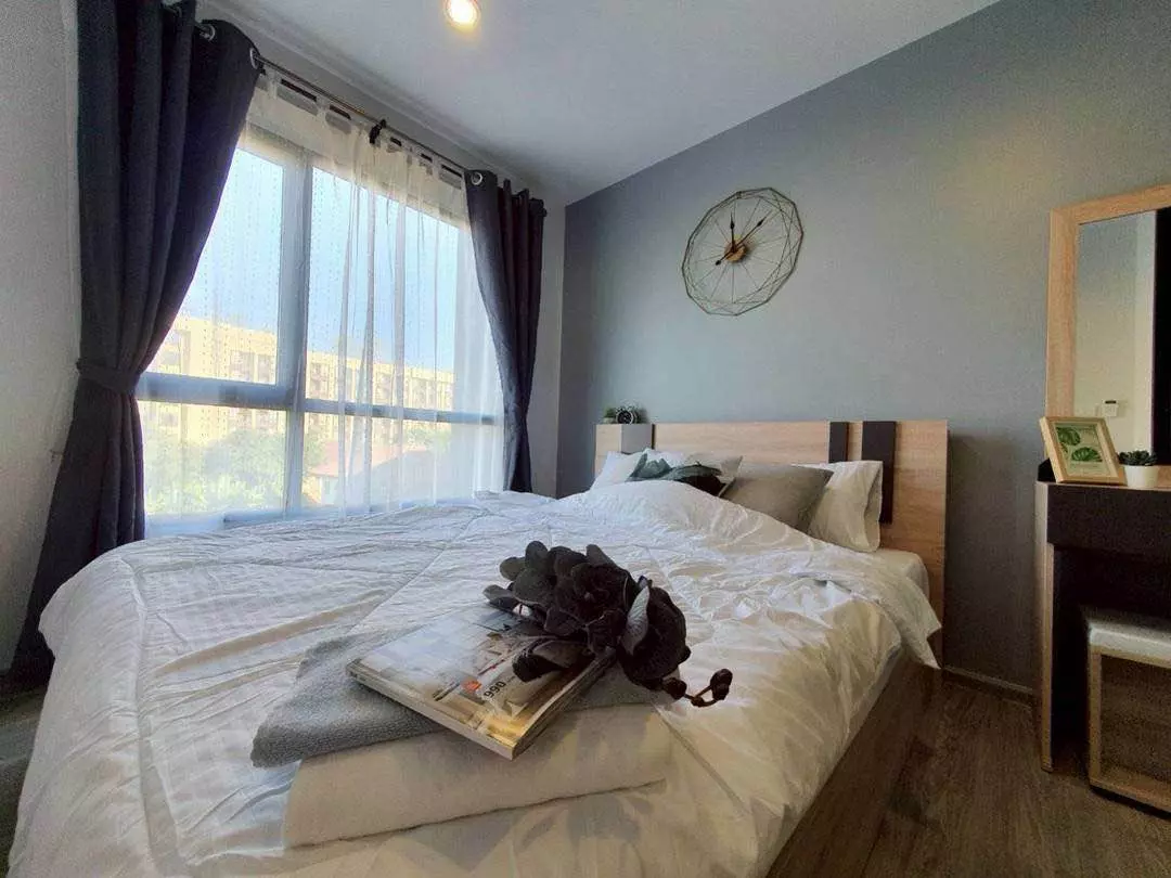 Modern bedroom in 1-bed condo for rent at Reach Phahonyothin 52 with oak headboard bed and large window view