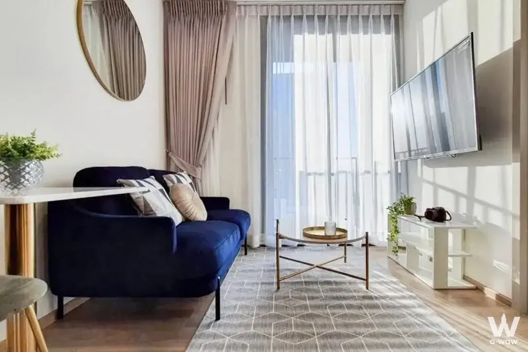 Navy velvet sofa and gold mirror in the living room of this 2-bed condo for rent at Oka Haus