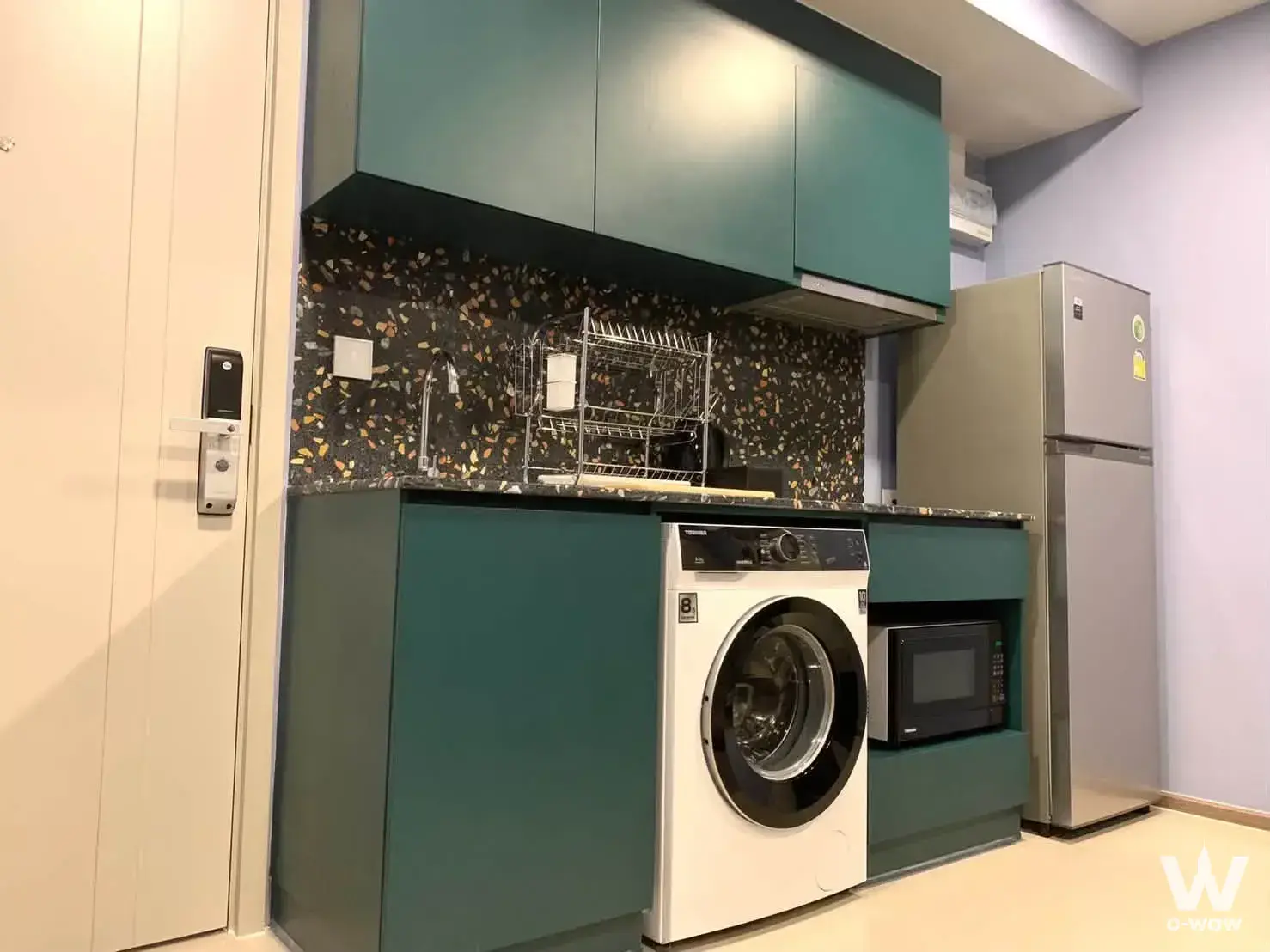 Modern kitchen with teal cabinets and terrazzo countertops in 1-bed condo for rent at THE BASE Sukhumvit 50