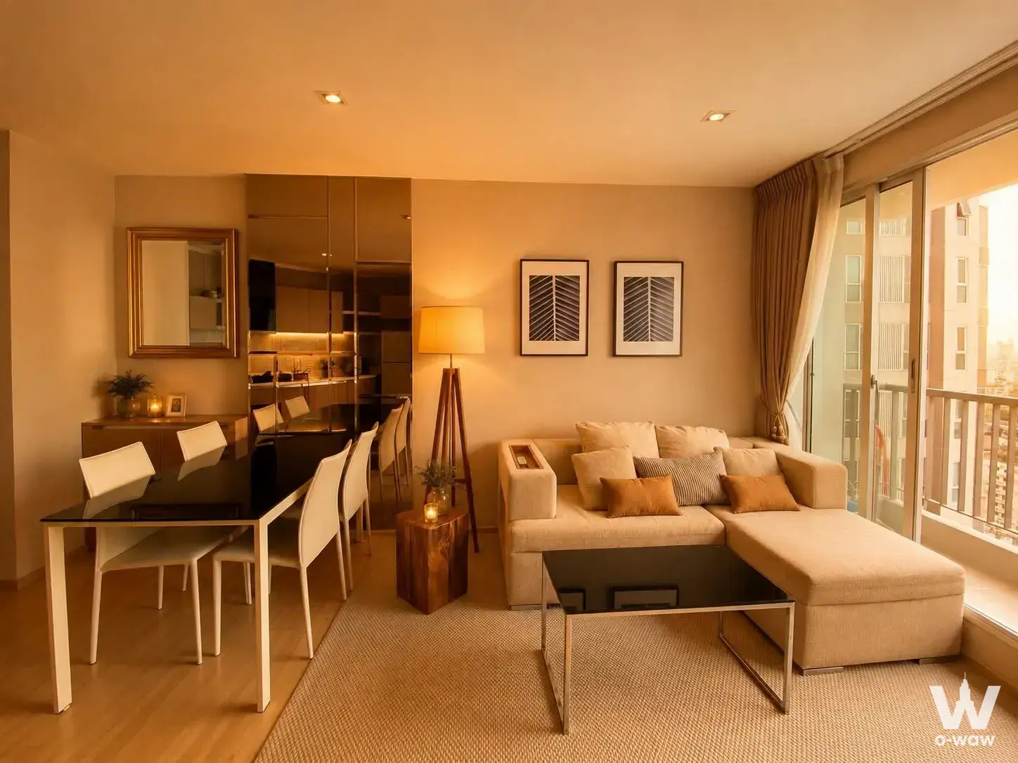 Living and dining area in RHYTHM Sathorn with L-shaped sofa, glass table, and balcony access
