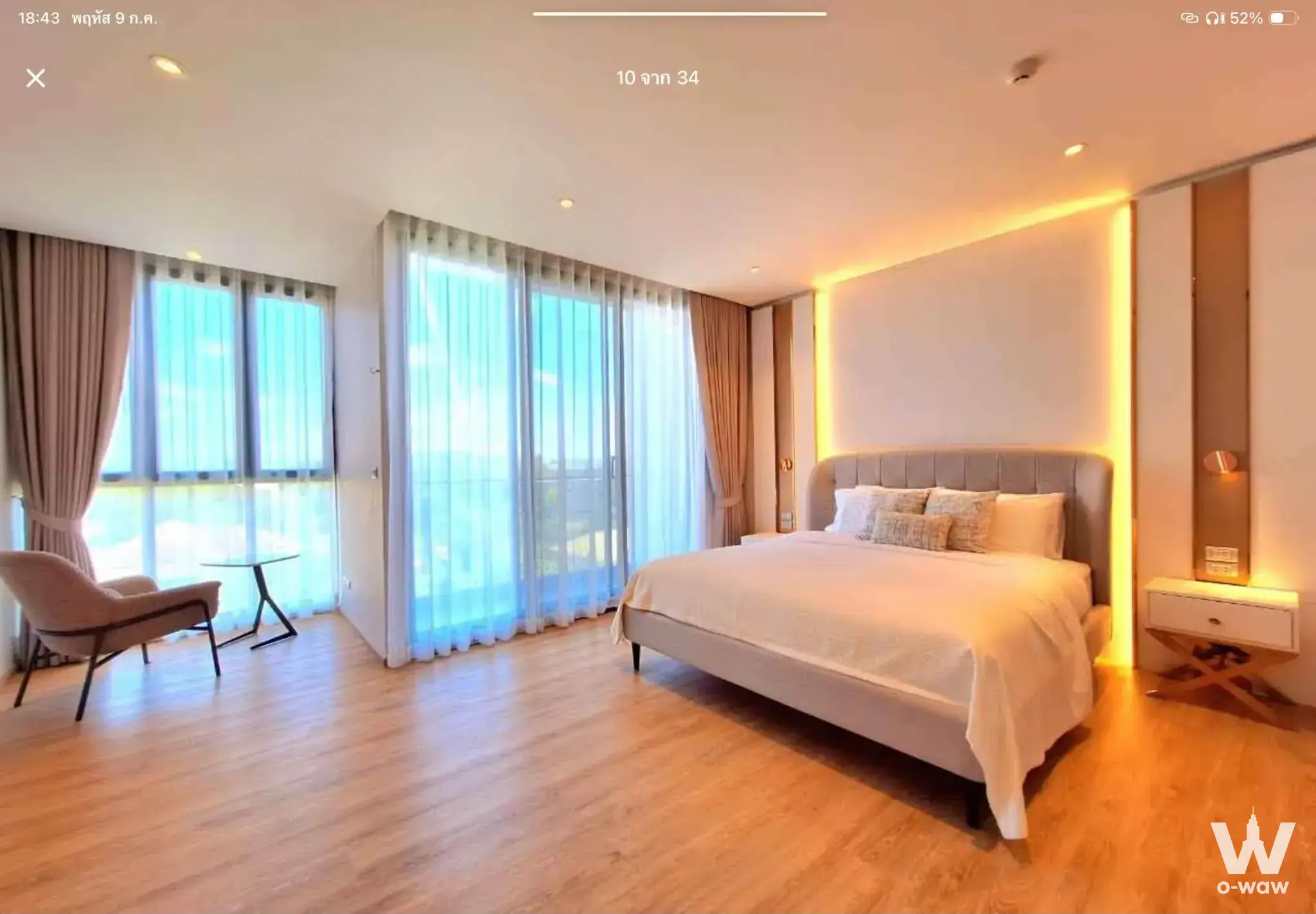 Spacious master bedroom in Bearing Residence 3-bed condo with grey bed, wood floors, and floor-to-ceiling windows
