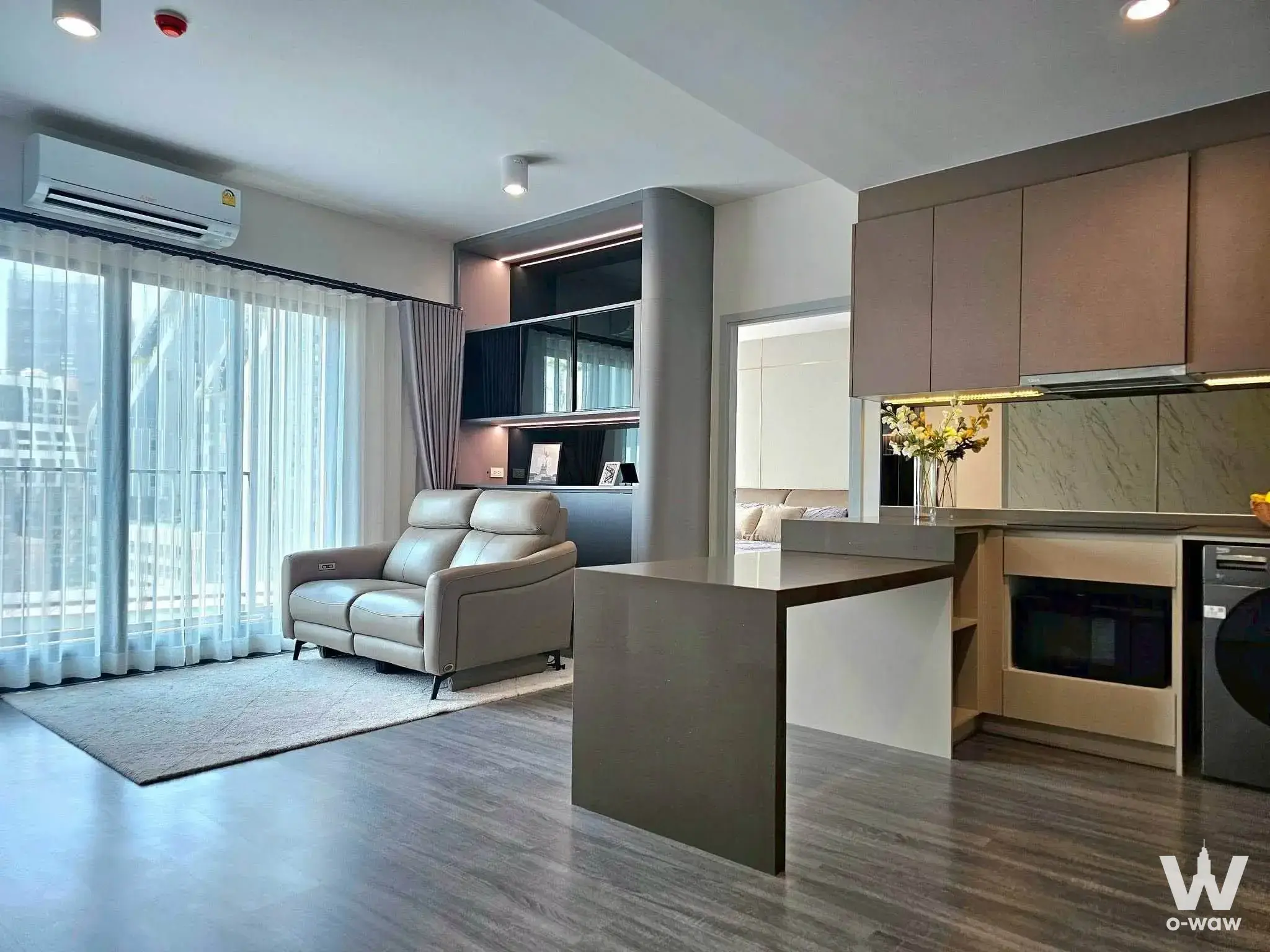 Open-plan living area and kitchenette in 2-bed condo for sale at IDEO Chula-Sam Yan with balcony views