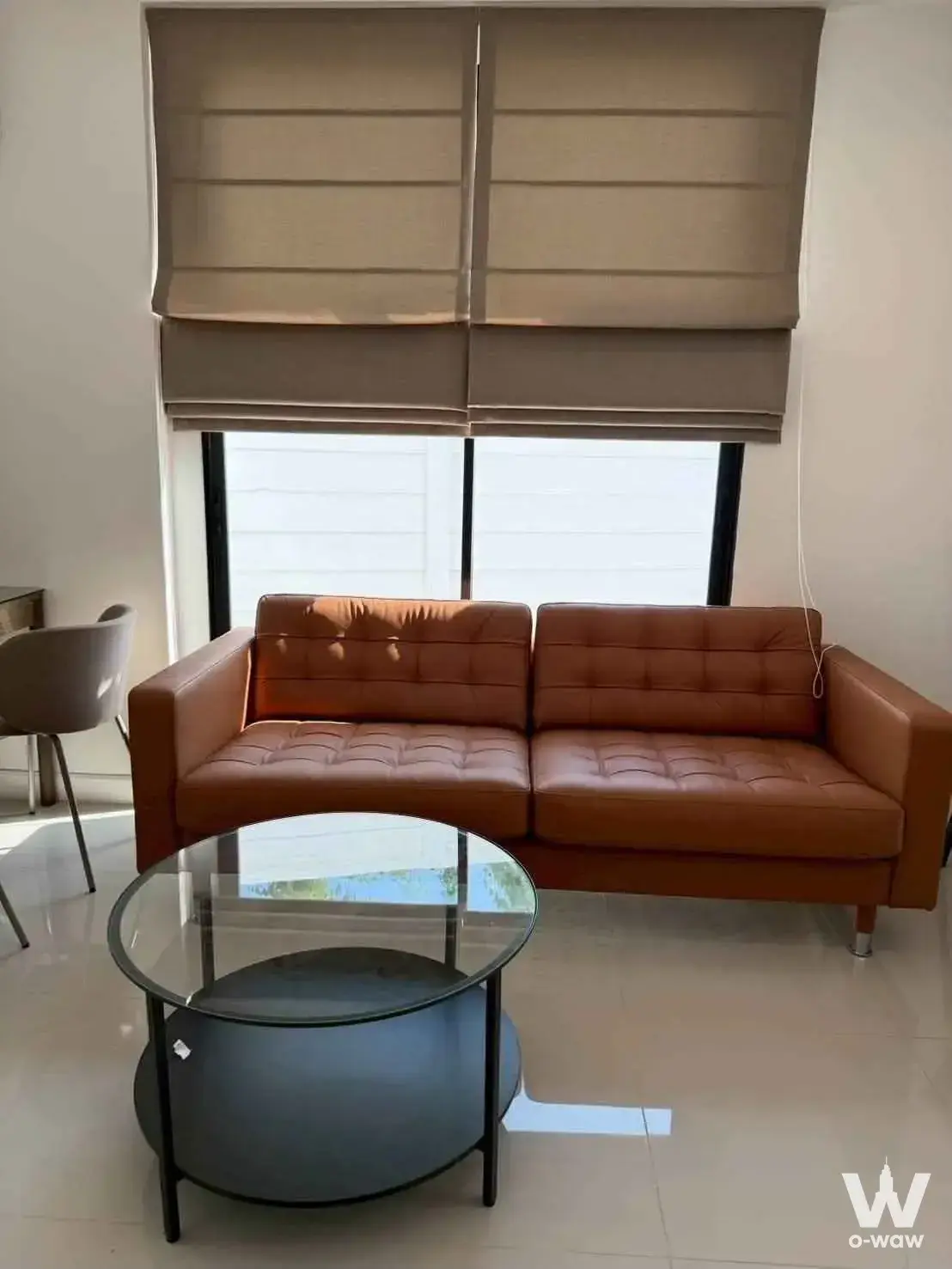 Modern living room with caramel leather sofa and glass coffee table in 3-bed townhouse for rent at Areeya Mandarina