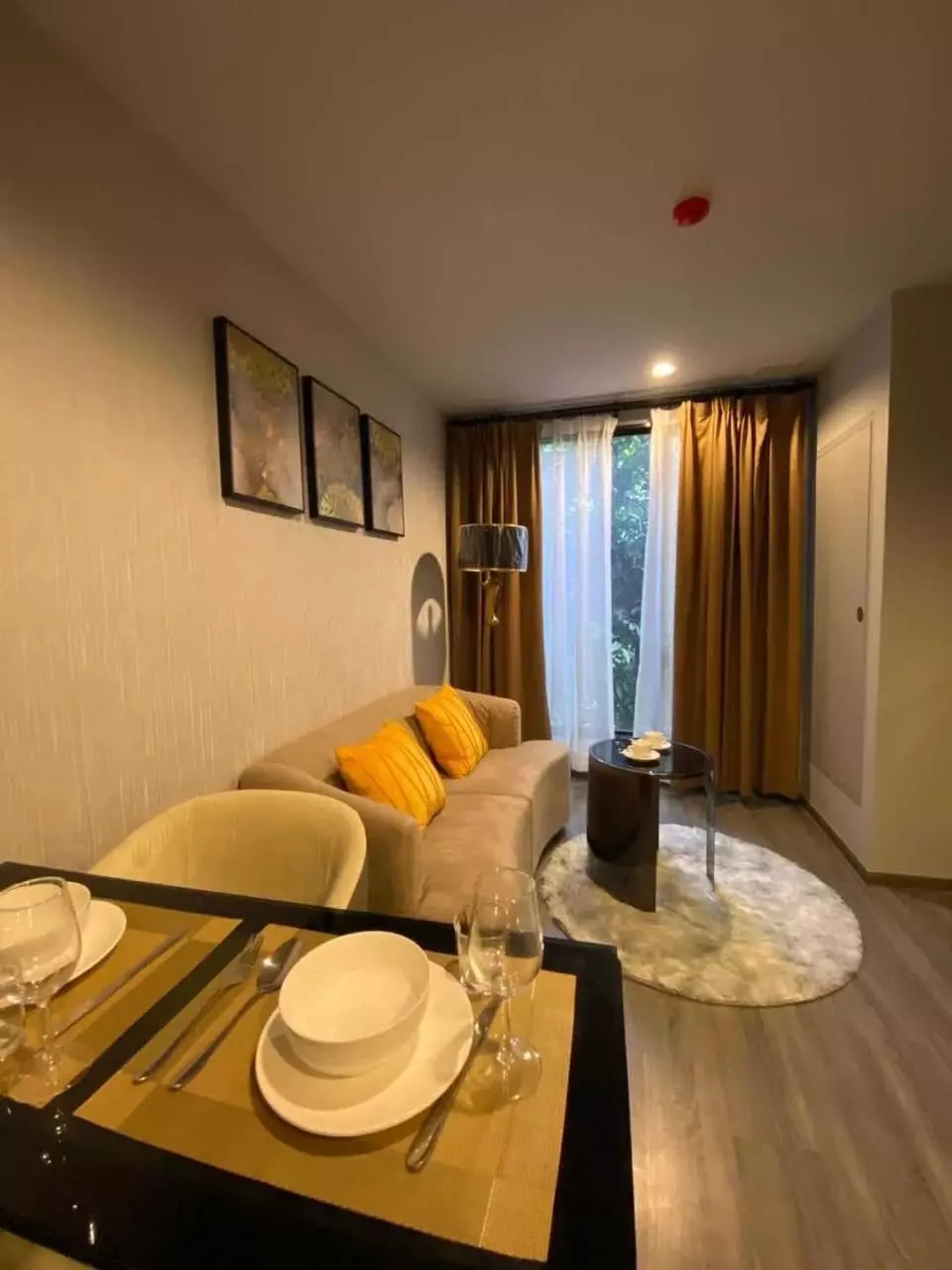 Modern dining area with black table and yellow accents in 1-bed condo for rent at Ideo Mobi Sukhumvit 40