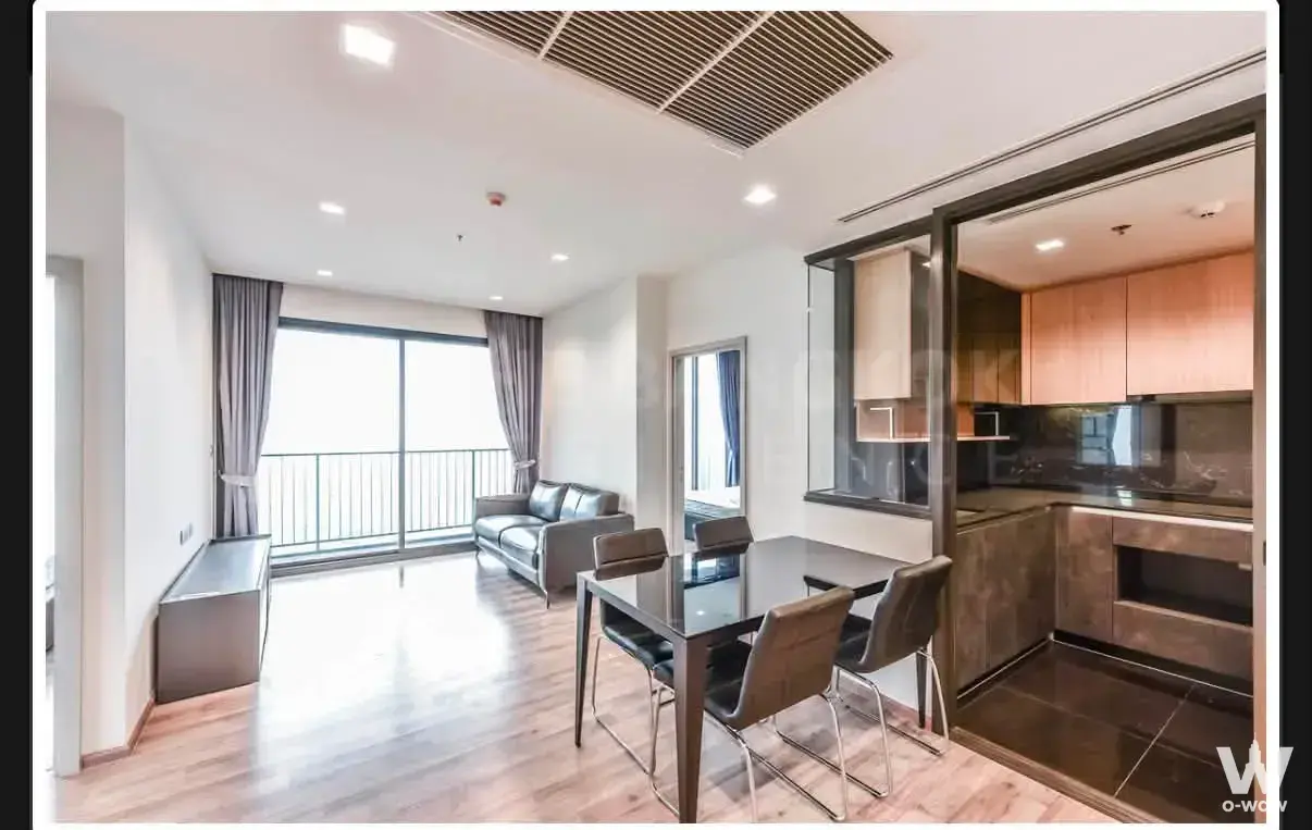 Living and dining area in THE LINE Chatuchak-Mo Chit condo with leather sofa and kitchen