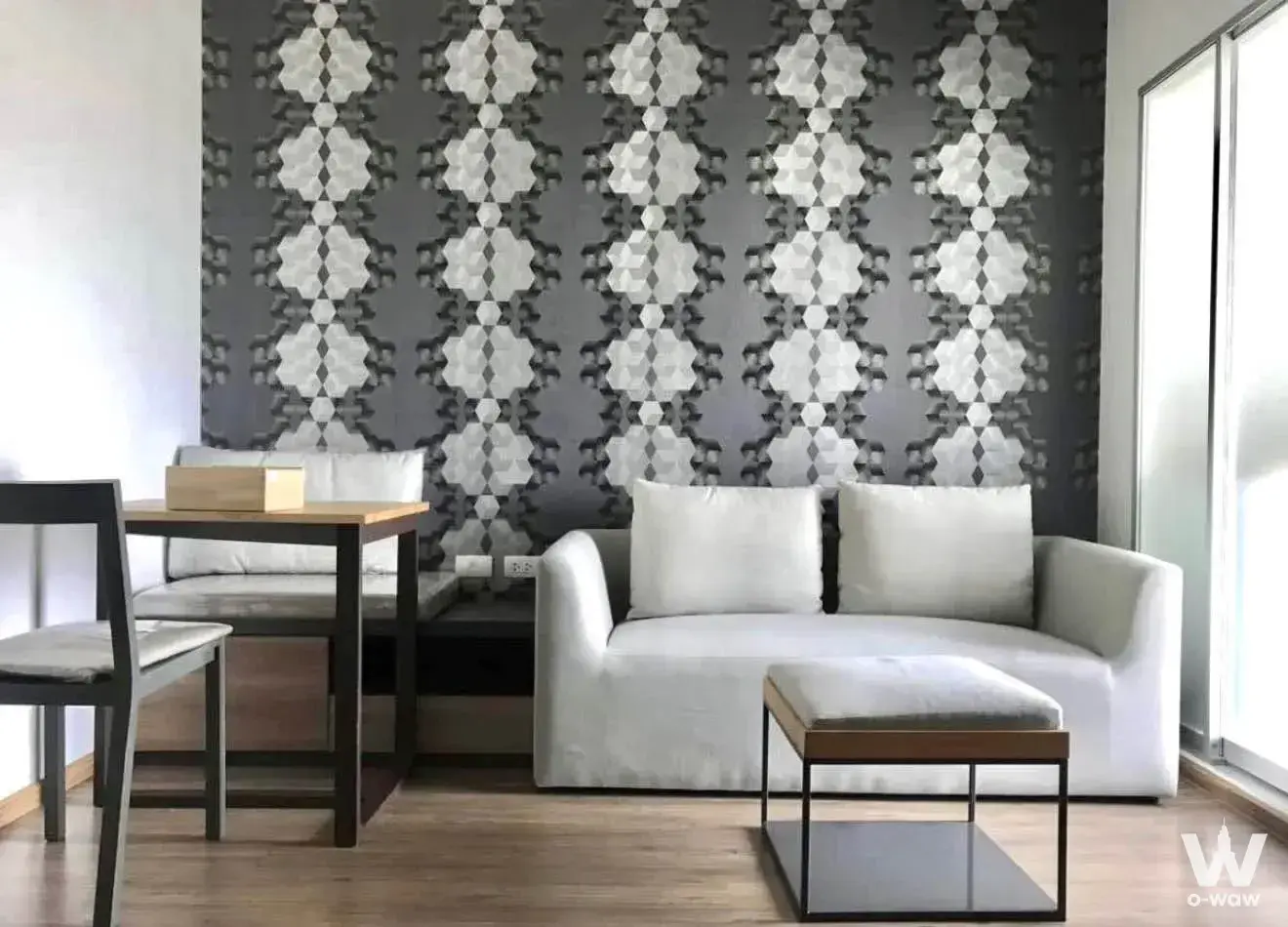 Modern living room with geometric wallpaper, white sofa, and floor-to-ceiling windows in 1-bed condo for rent at U Delight