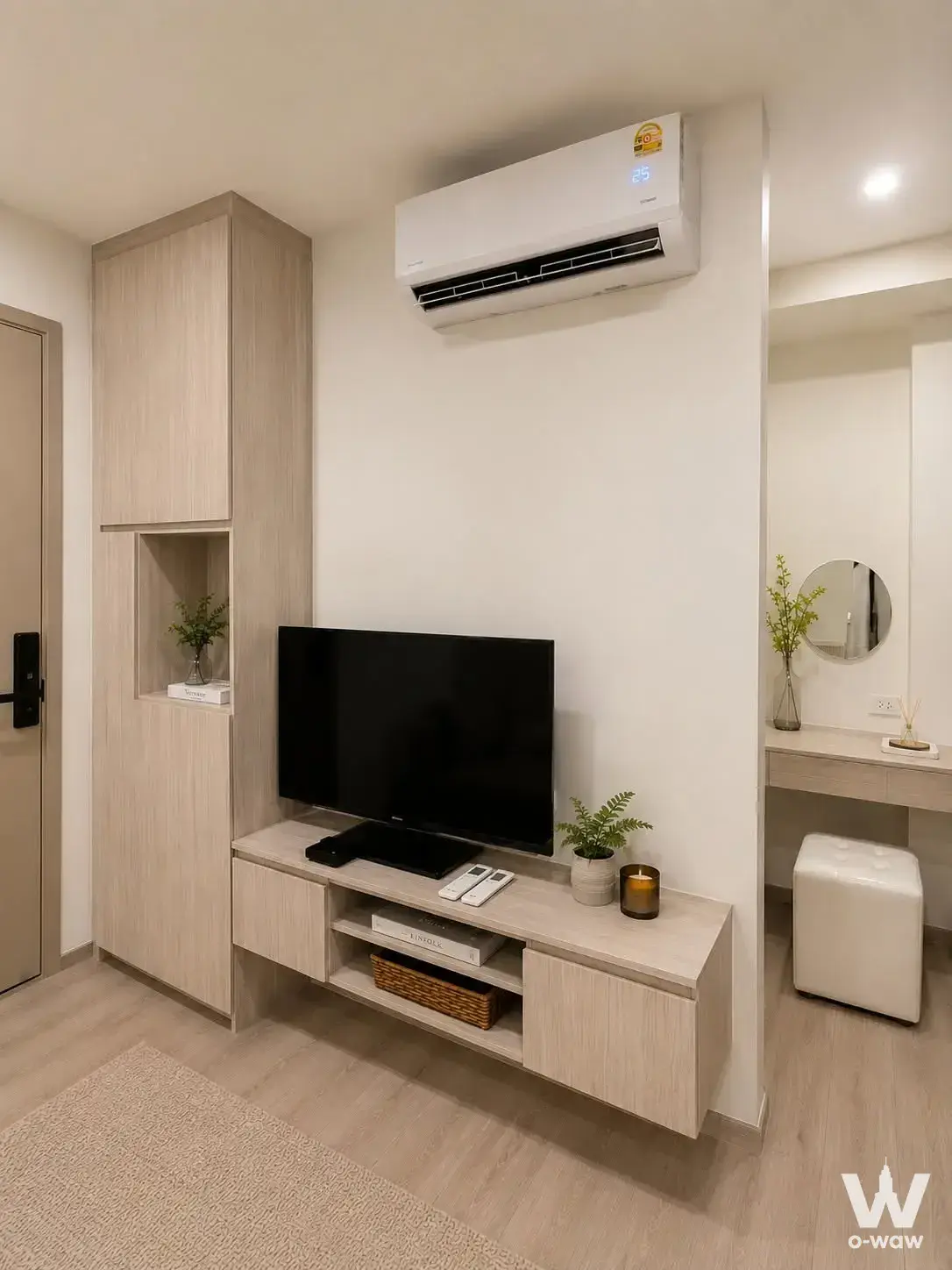 Modern 1-bed condo living room in Origin Place Bangna with light wood flooring, TV console, and vanity desk