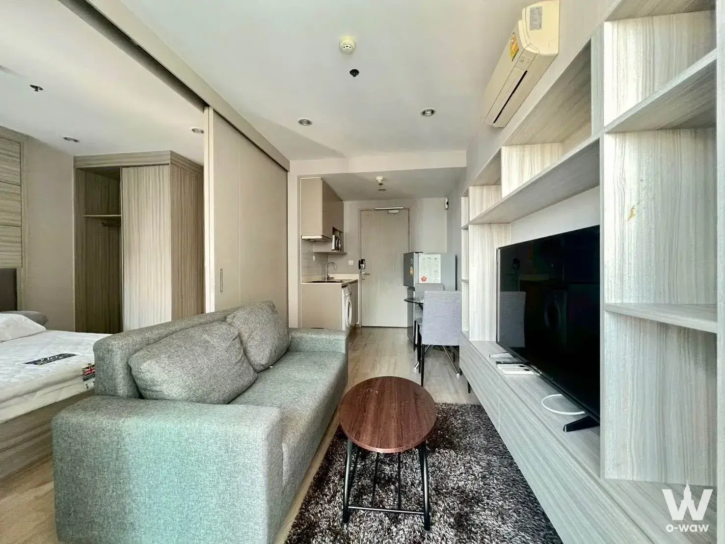 Modern 1-bed condo for rent in Ideo Q Chula-Samyan with open-plan living, grey sofa, and light wood flooring