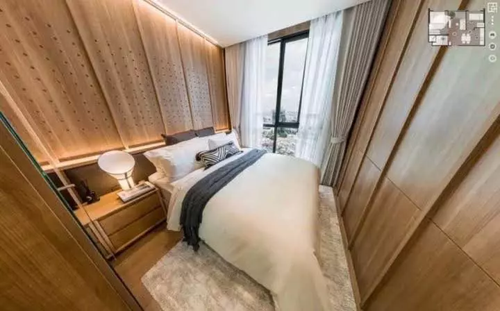 Modern bedroom with wood paneling and city views in 2-bed condo for rent at Rhythm Ekkamai Estate