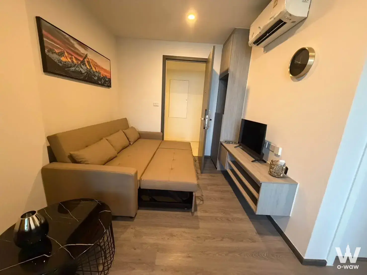 Living room in The Origin E22 Station condo featuring beige leather sofa and marble coffee table