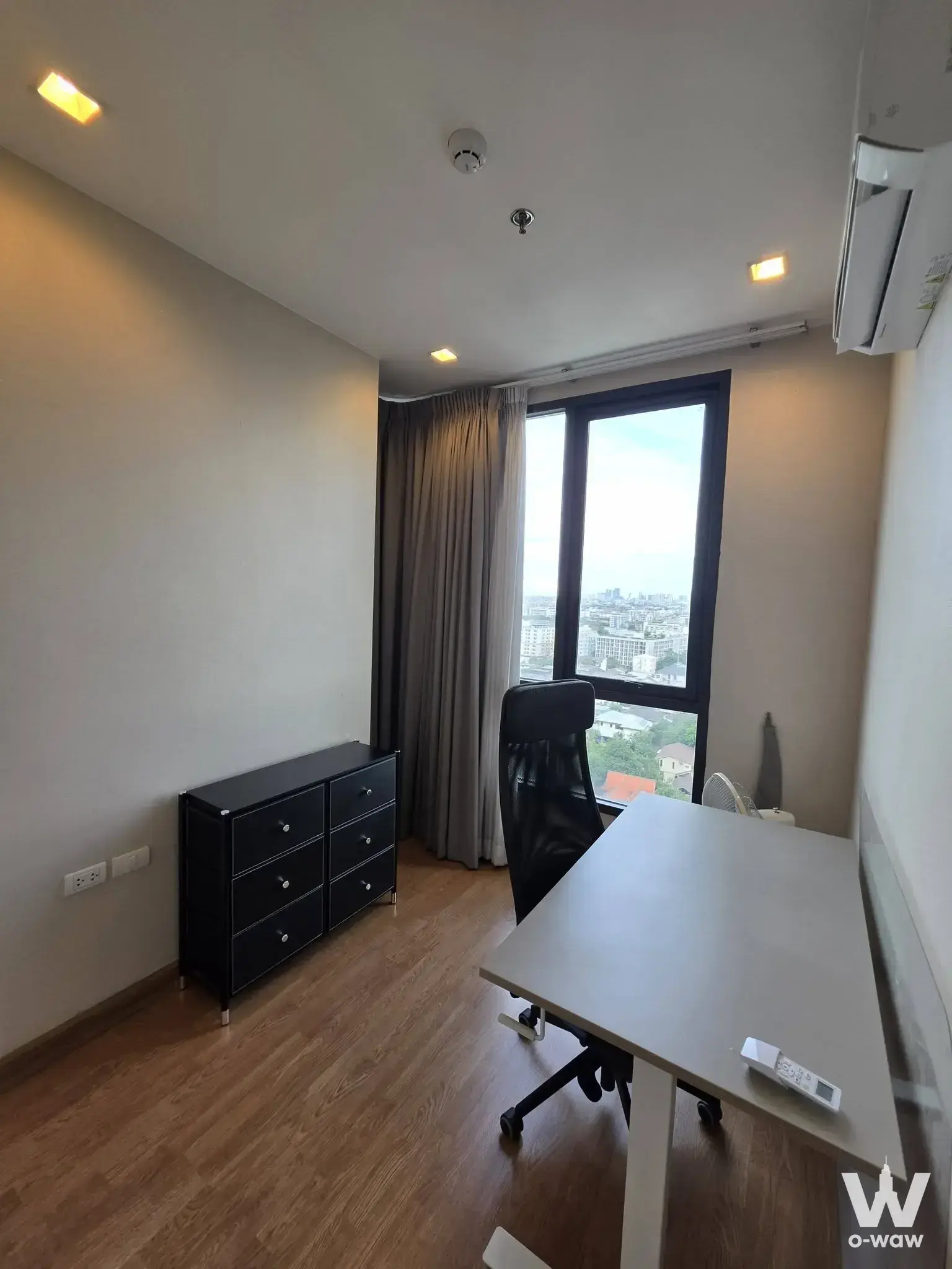 Home office with desk and city view in a 1-bed condo for rent at Q House Sukhumvit 79
