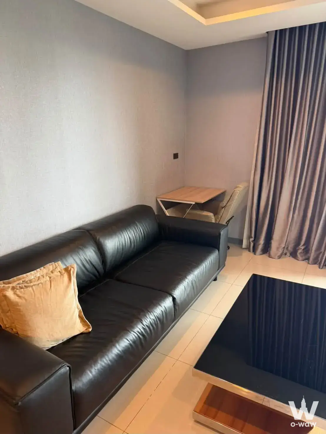 Modern living room in StarView Rama 3 condo with grey walls, cove lighting, and tan sofa