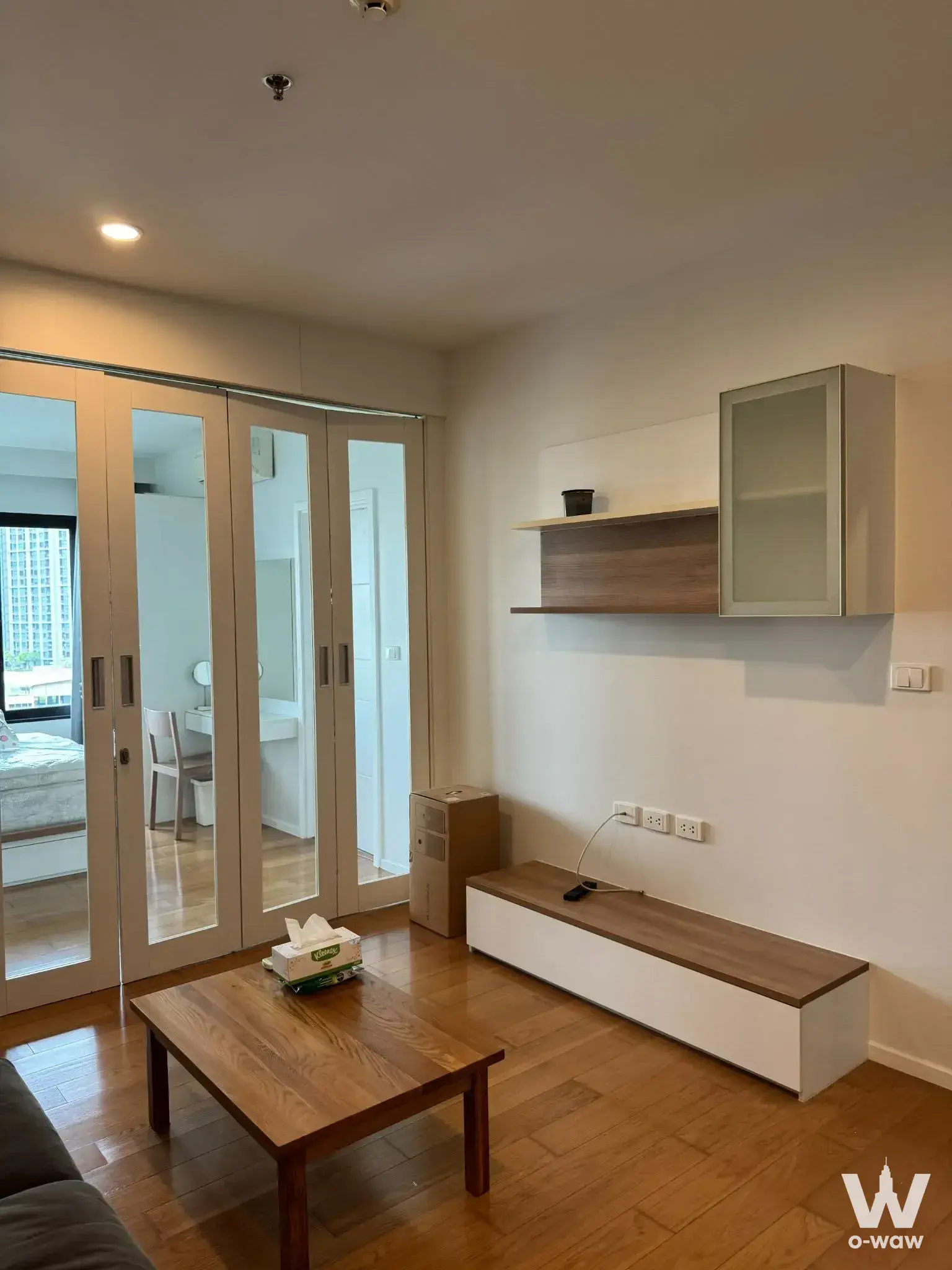 Living room in a 1-bed condo for sale at Blocs 77 featuring wood floors and folding glass doors
