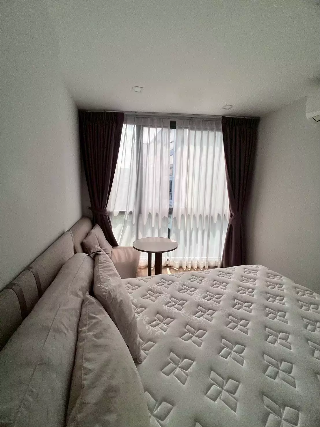 Modern bedroom in 1-bed condo for rent at The Nest Sukhumvit 71 with taupe headboard and wood floors